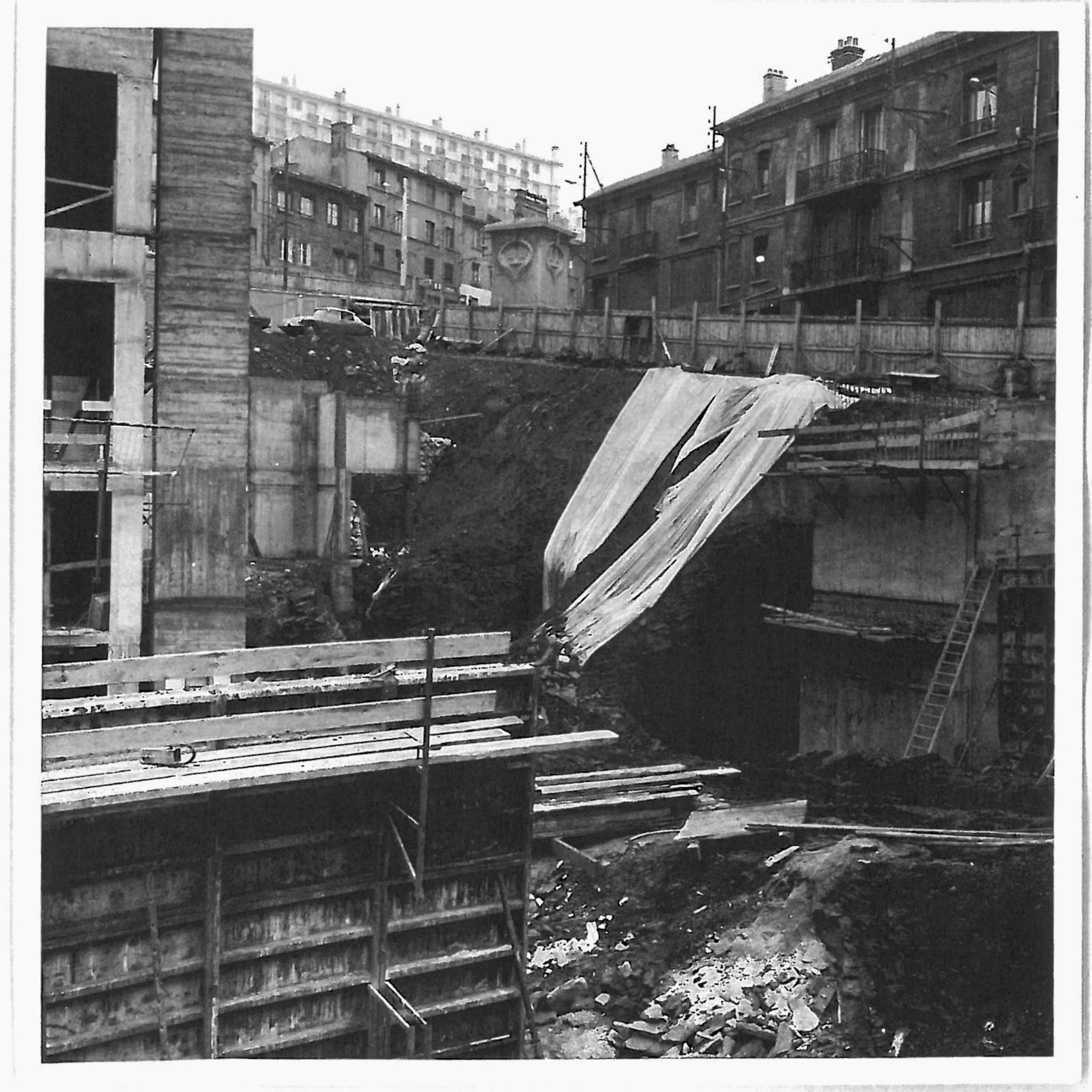 Vue de chantier en creux de l’ancien IGH Émile Loubet à Saint-Étienne, montrant le socle béton en cours de curage au pied des immeubles existants.
