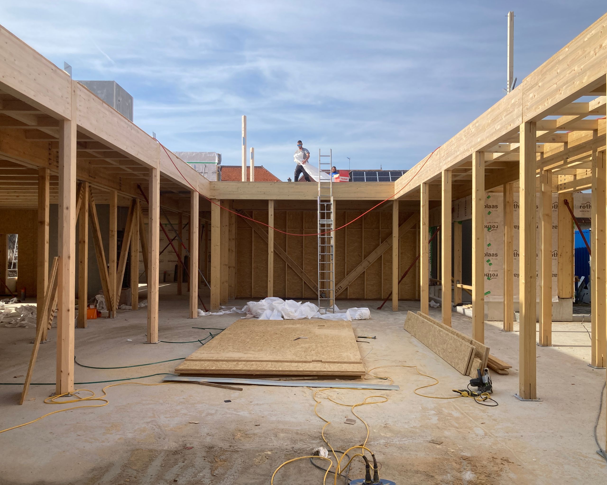 Chantier du groupe scolaire Louis Pergaud à Levier : structure bois apparente formant un atrium central ouvert, planchers et poteaux en ossature lamellé-collé.