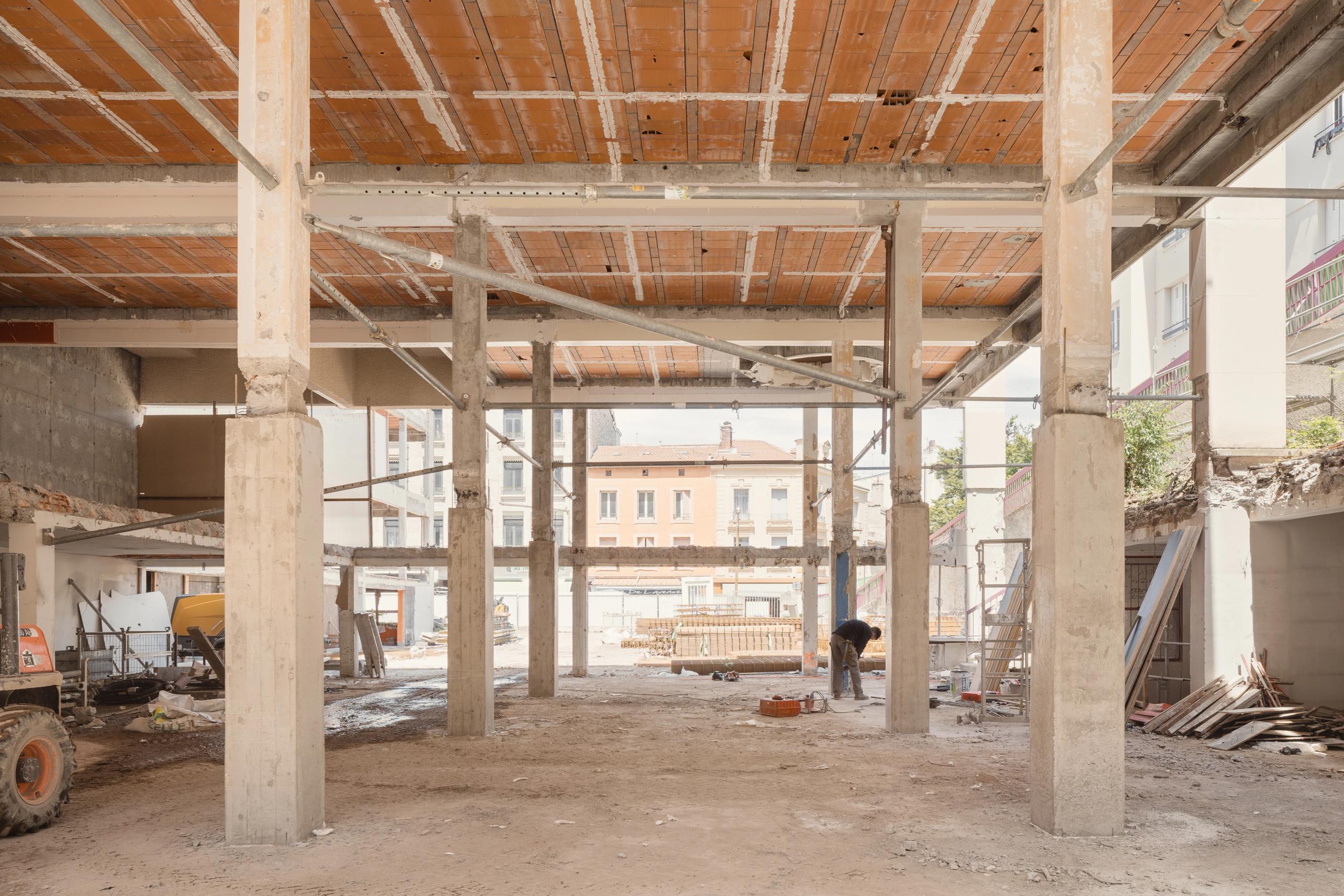 Vue intérieure du socle de l’ancien IGH Émile Loubet à Saint-Étienne, structure béton mise à nu en phase de curage, ouverte sur la cour urbaine.