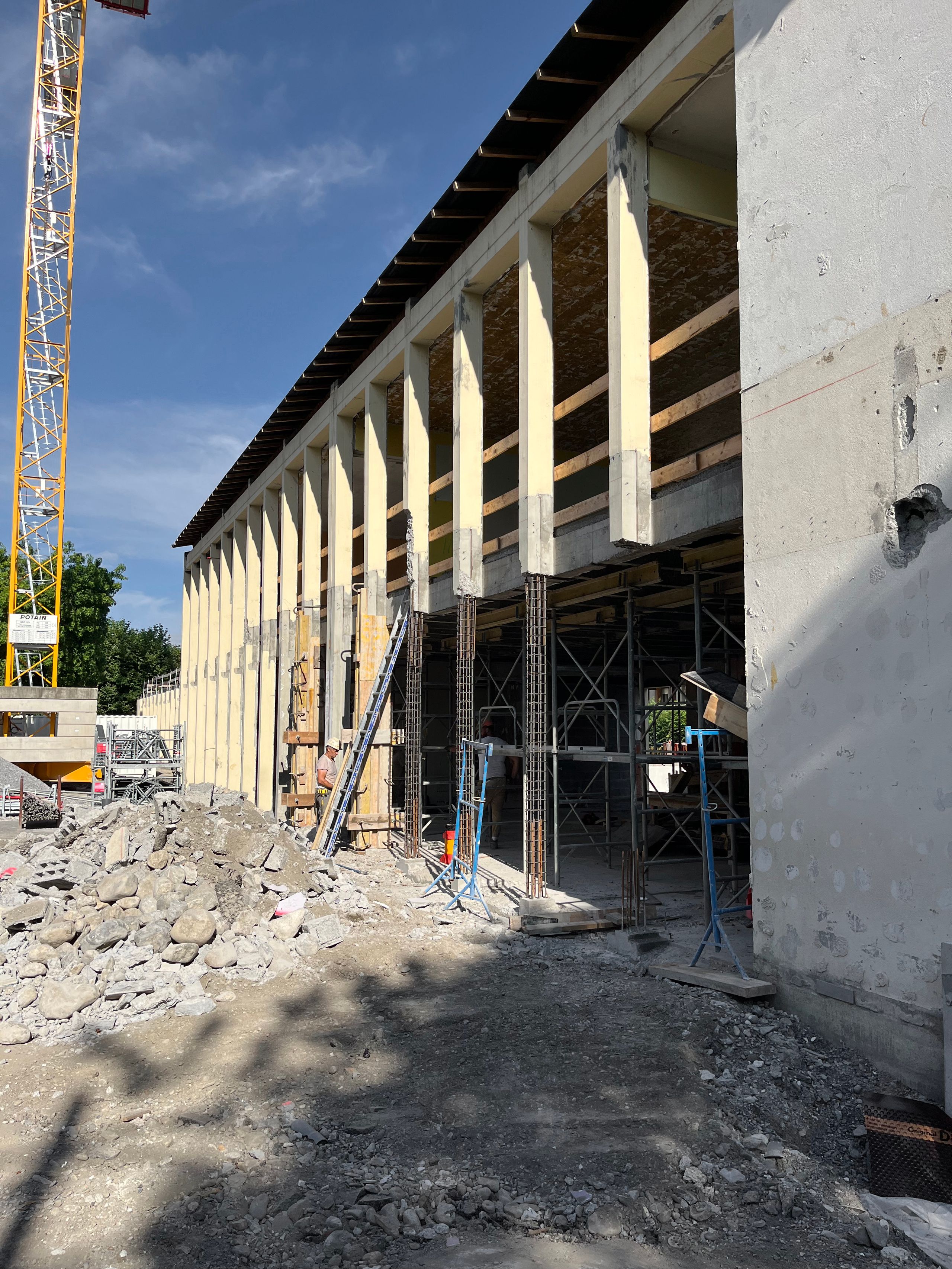 Chantier de restructuration du groupe scolaire du Bouchet à Bonneville : façade en béton armé mise à nu, structure existante étayée et en cours de renforcement.