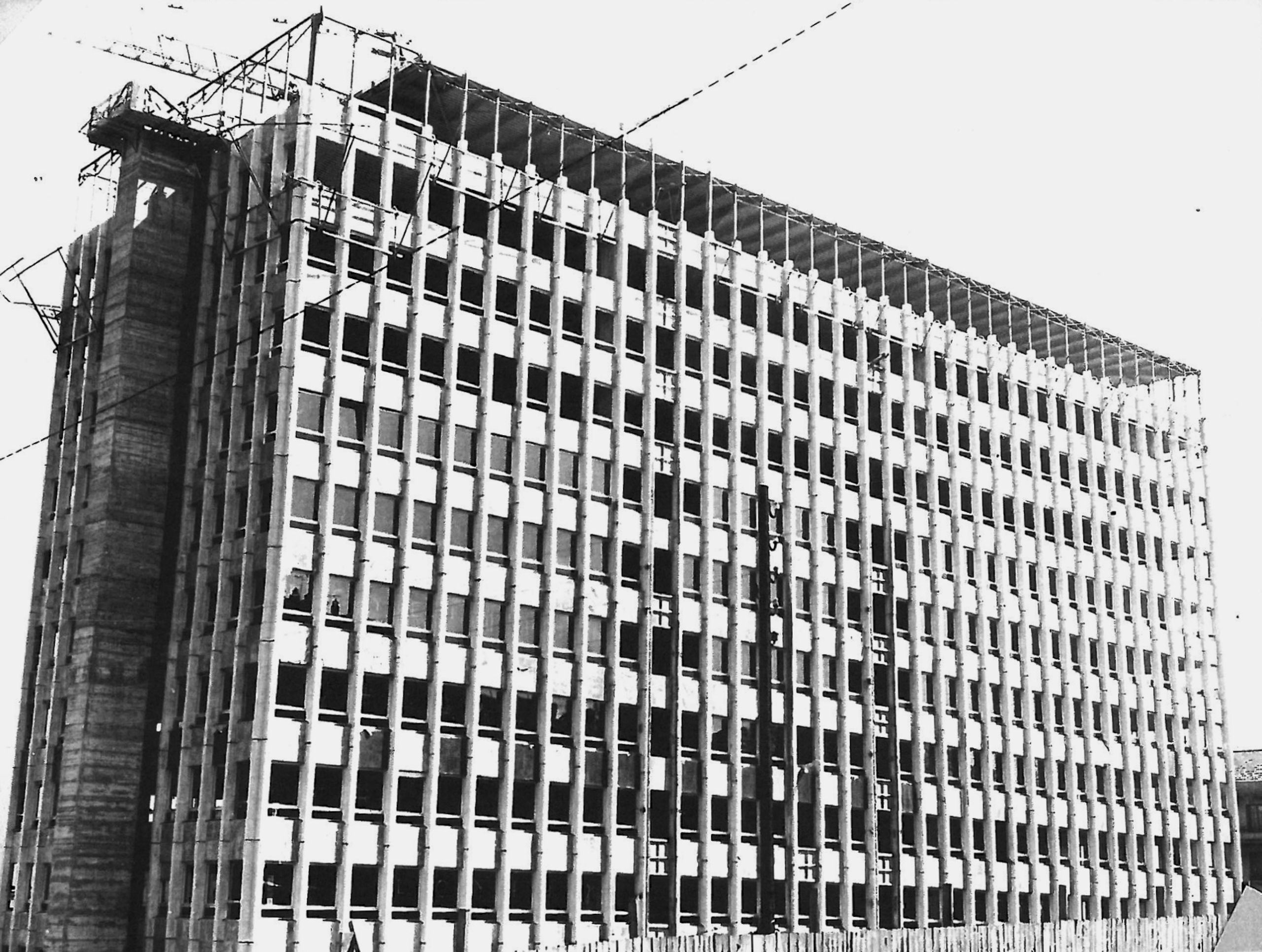 Vue de l’ancien IGH Émile Loubet à Saint-Étienne, tour de bureaux des années 1970 en béton, façade trame régulière en curage avant réhabilitation mixte.