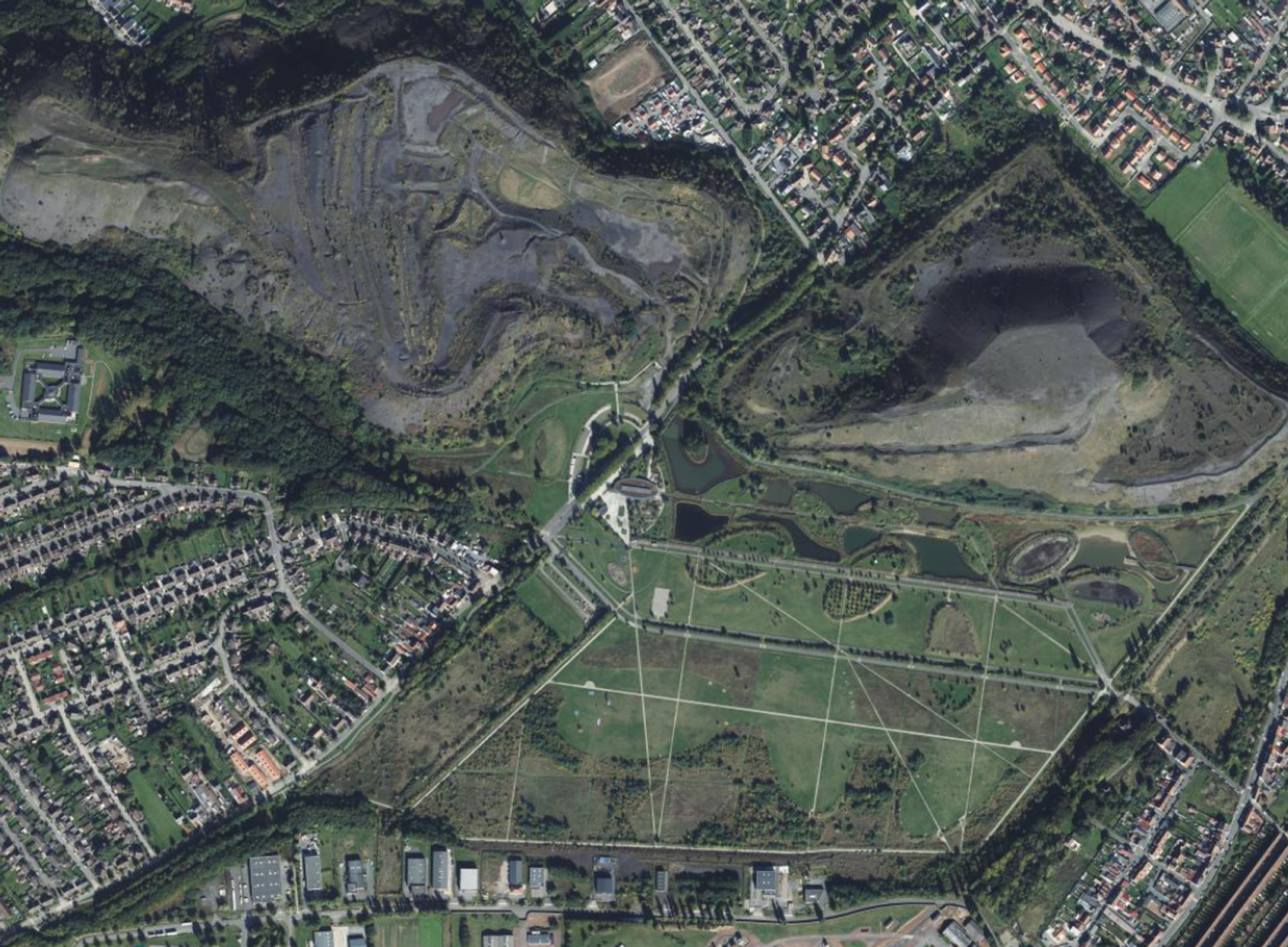Vue aérienne du Parc des Îles à Hénin-Beaumont, montrant la trame paysagère, les plans d’eau et les anciens terrils autour du pavillon Aquaterra.