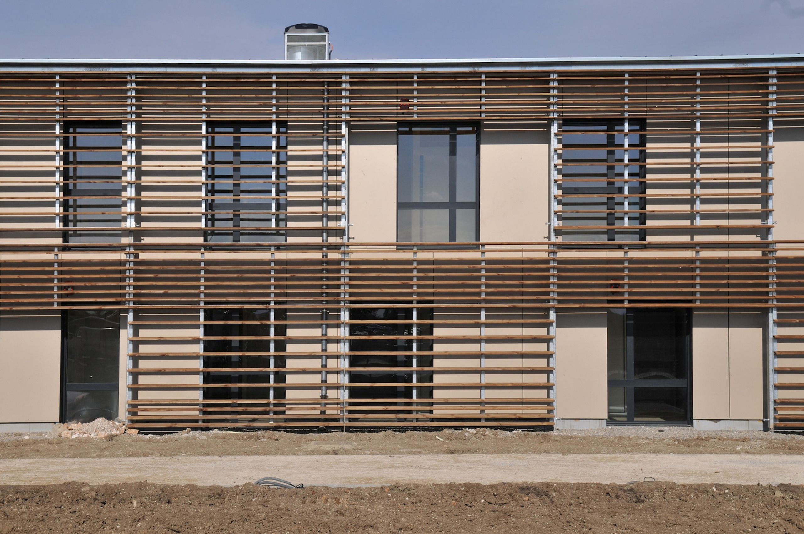 Façade de l’EHPAD de Sault par Tectoniques, volume compact à ossature bois, brise-soleil horizontaux en lames de bois filtrant les baies vitrées sur deux niveaux.