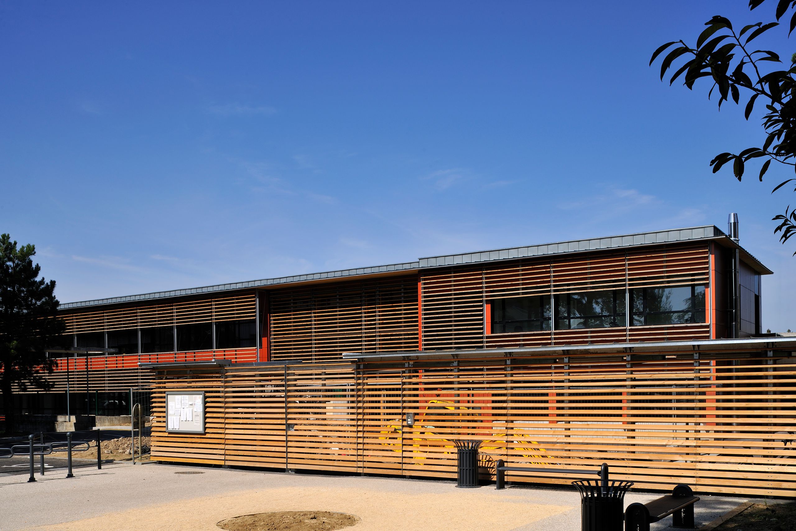 Façade du groupe scolaire Antoine de Saint-Exupéry à Annemasse, volume linéaire à ossature bois, bardage à lames horizontales filtrant les vitrages sur deux niveaux.