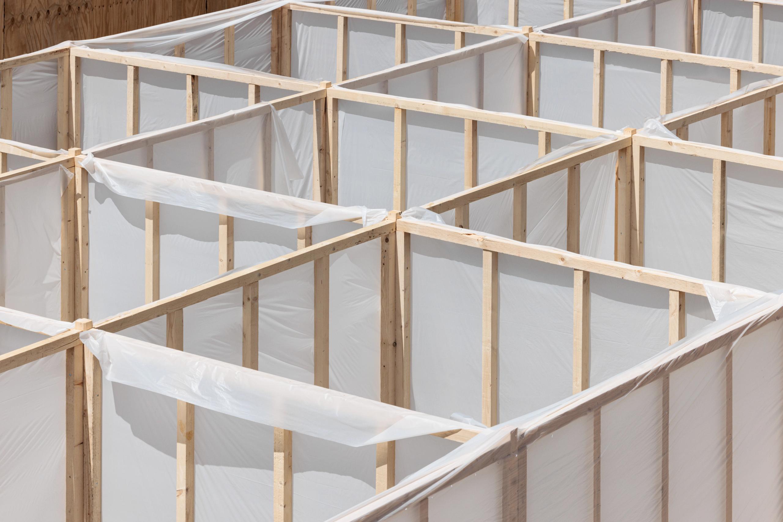 Workshop 60x60 à Versailles : trame dense en ossature bois standard, panneaux manuportables en film plastique translucide formant un parcours labyrinthique.