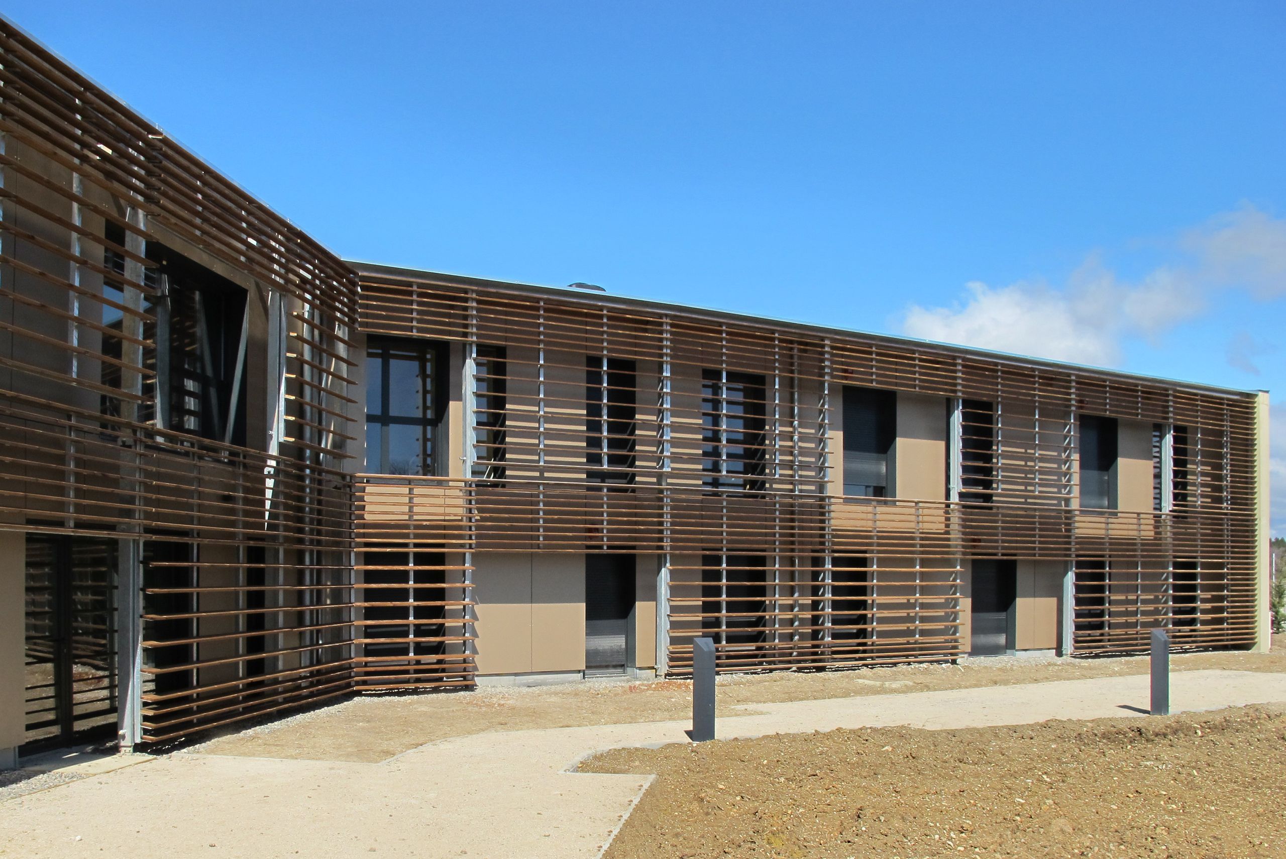 Façade de l’EHPAD de Sault par Tectoniques, volume en H à deux niveaux, bardage bois ajouré formant brise-soleil devant les chambres ouvertes sur le paysage.