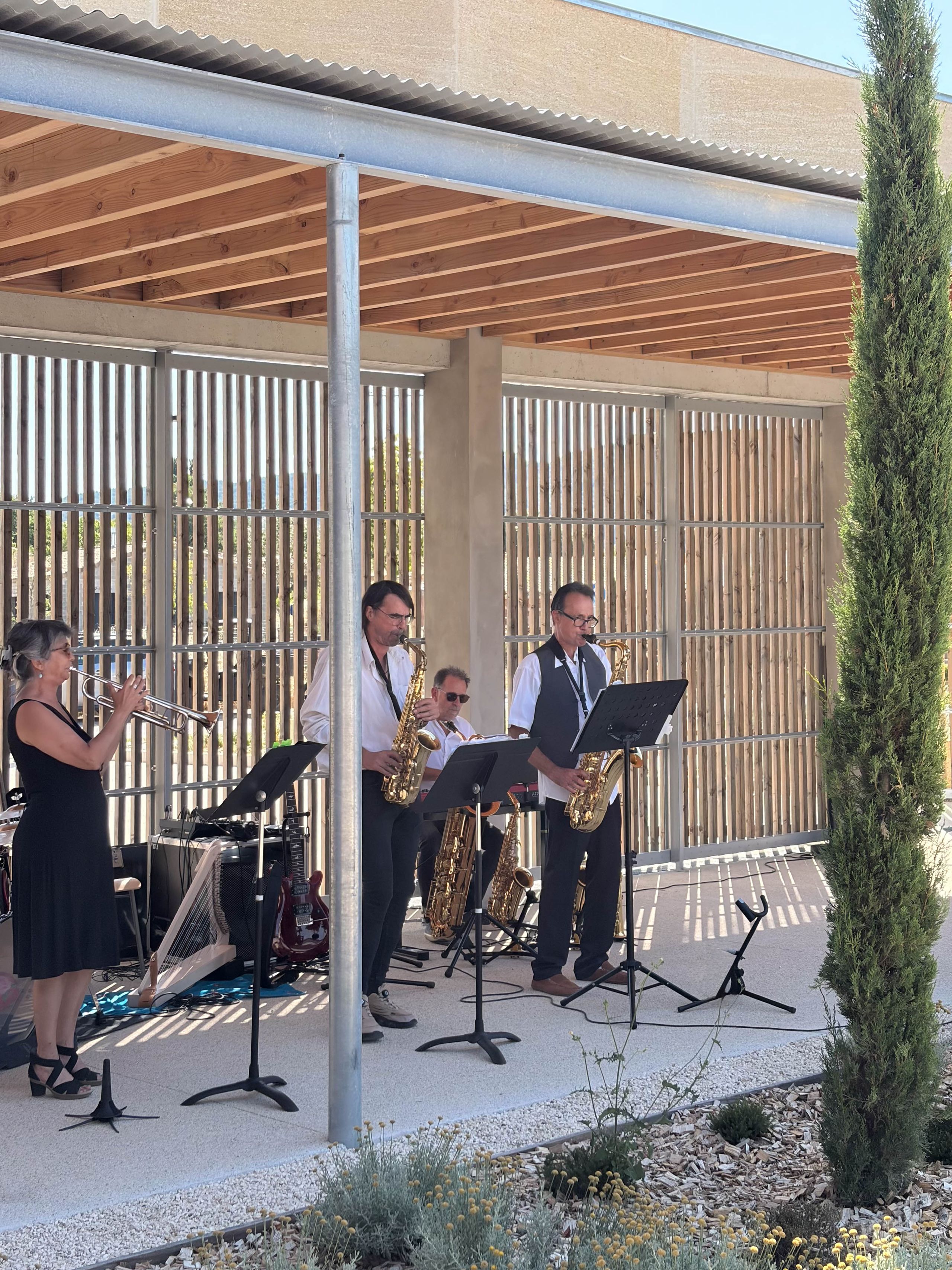 Concert sous la galerie du Pôle culturel de Vaison-la-Romaine, entre charpente bois, poteaux métalliques et claustra vertical.