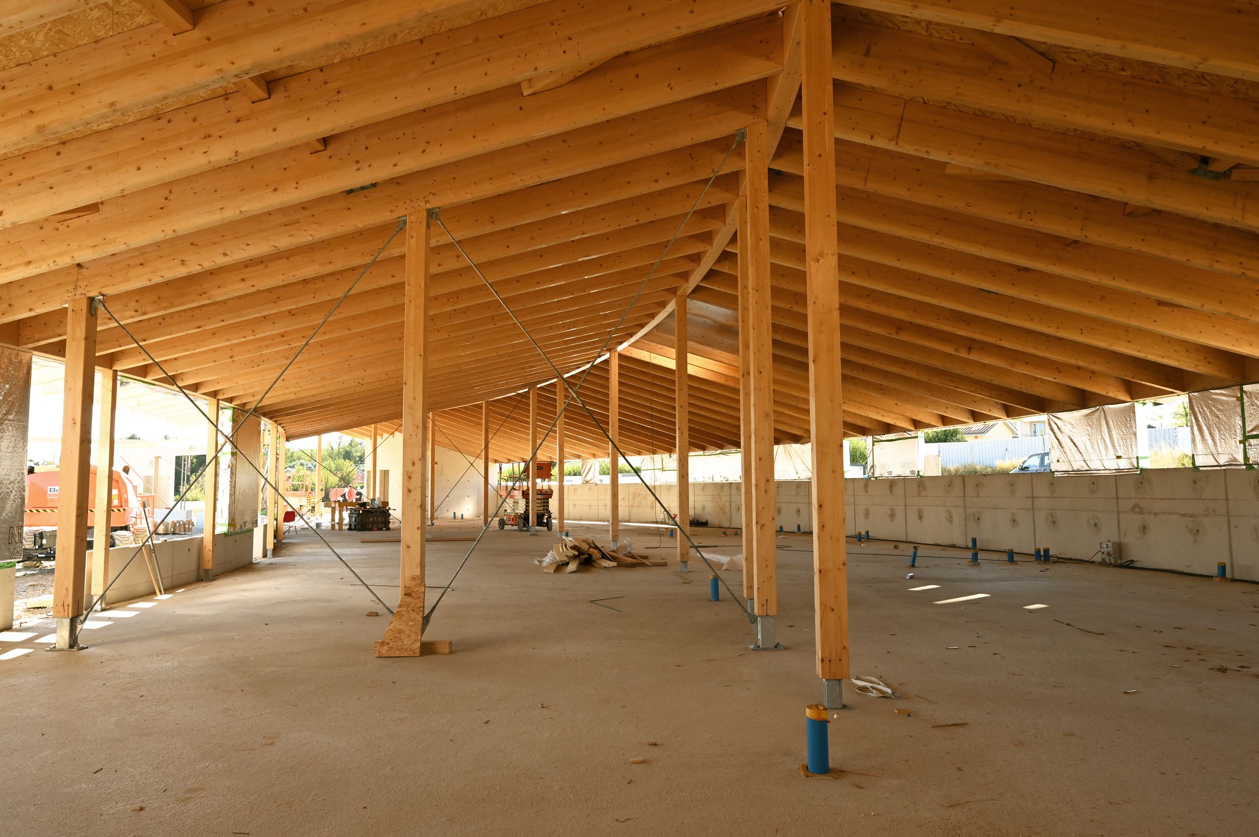 Chantier du groupe scolaire Saint-Ignace à Vienne : ossature poteaux-poutres en bois et charpente rayonnante couvrant un vaste plateau ouvert.