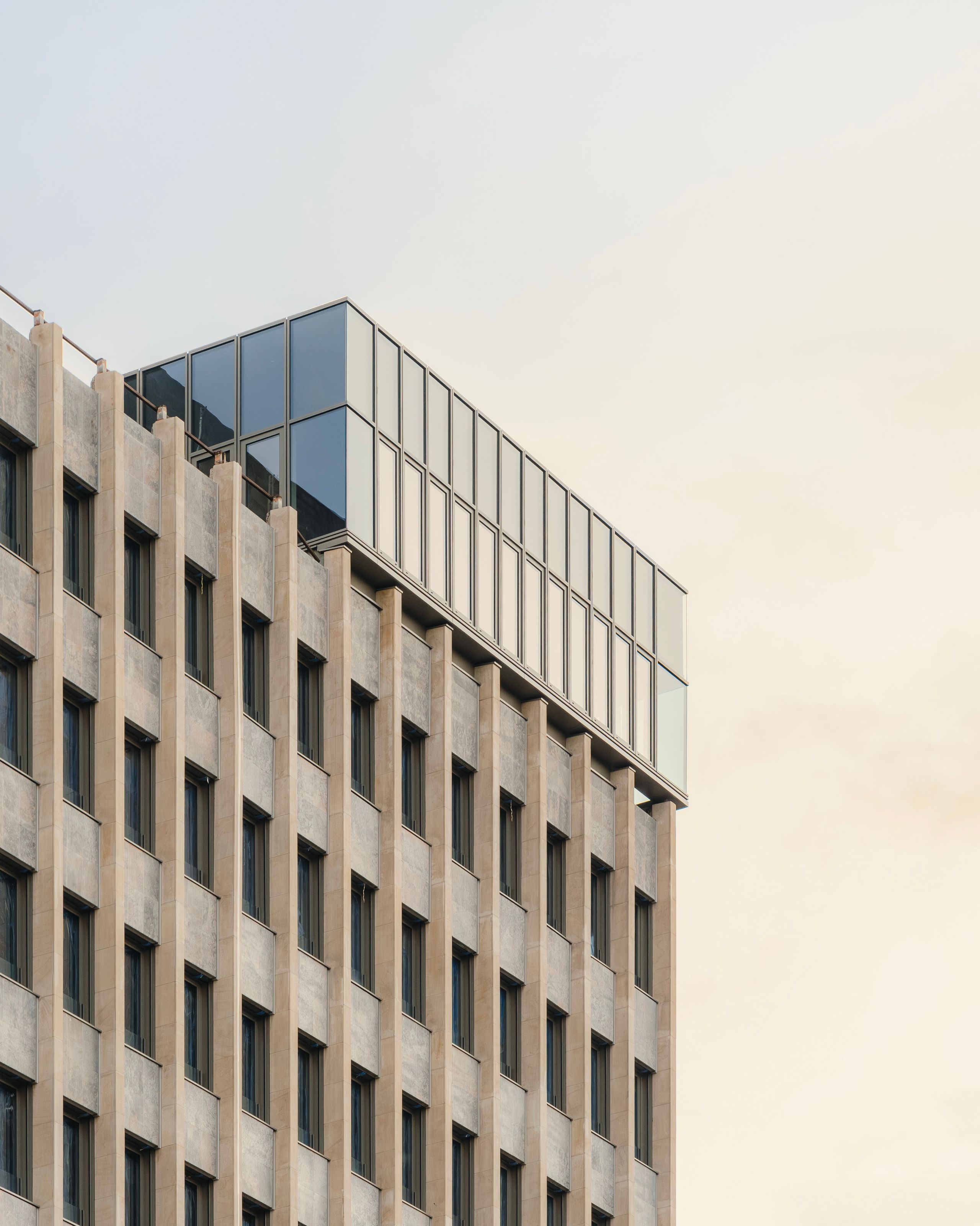 Façade rythmée de l’ancien IGH Émile Loubet à Saint-Étienne, mise en valeur par un attique vitré contemporain ajoutant un volume léger en surélévation.