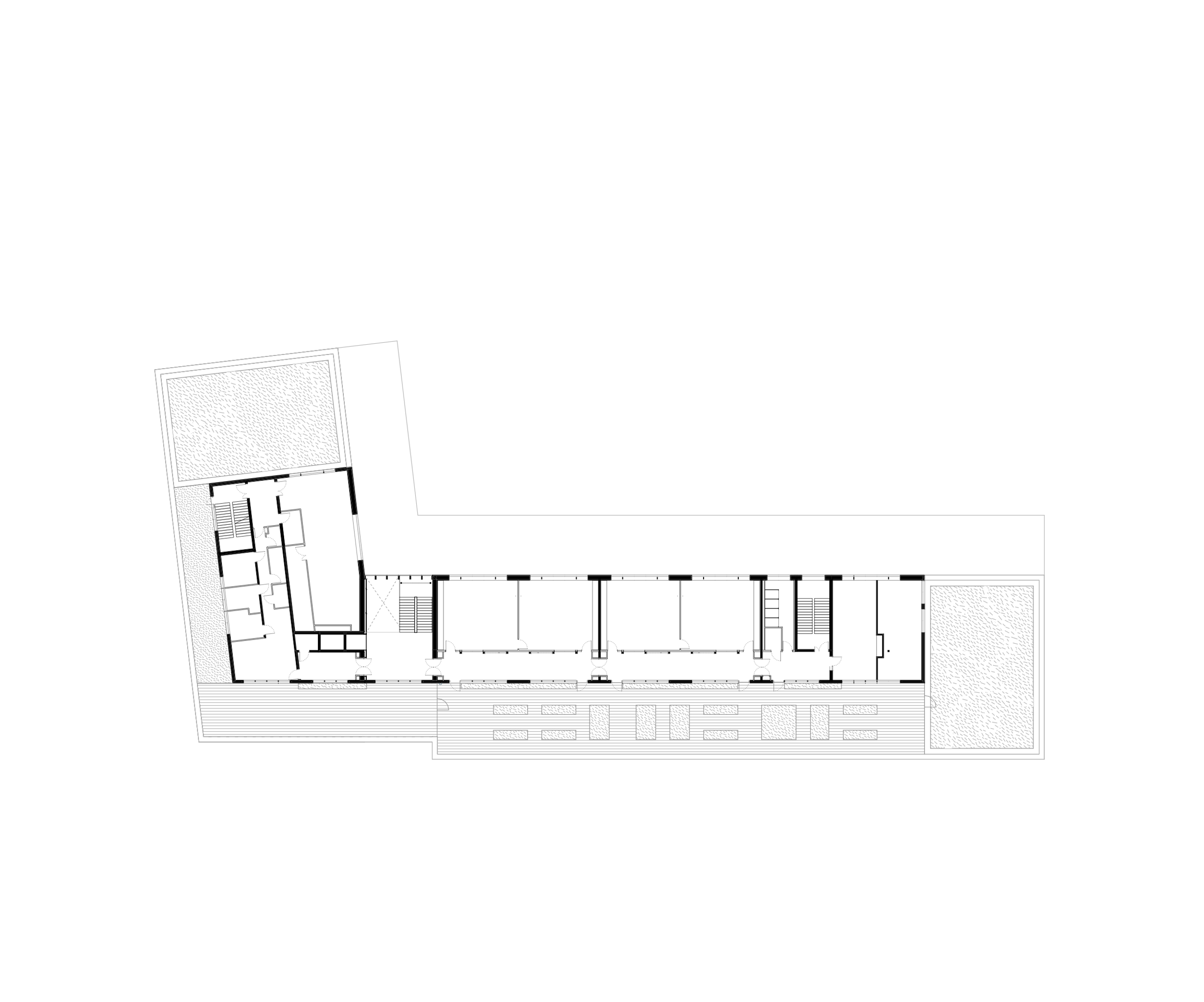 Plan en L du School complex J.F. Kennedy à Lyon, montrant en enfilade les salles de classe, circulations, noyaux de services et patios latéraux paysagers.