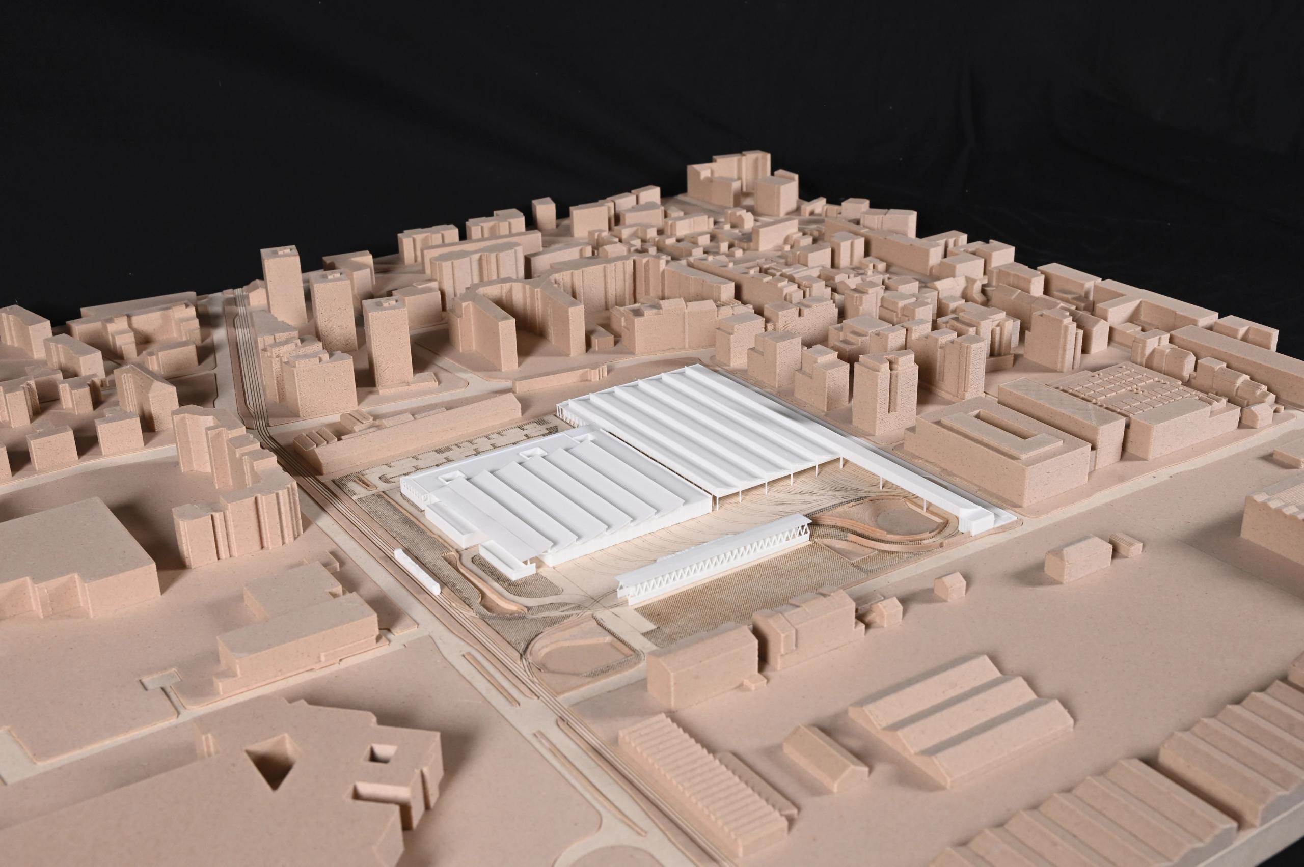 Maquette urbaine du centre de maintenance de tramway à Lyon, volumes blancs des halles techniques et voies ferrées intégrés dans un tissu bâti dense.