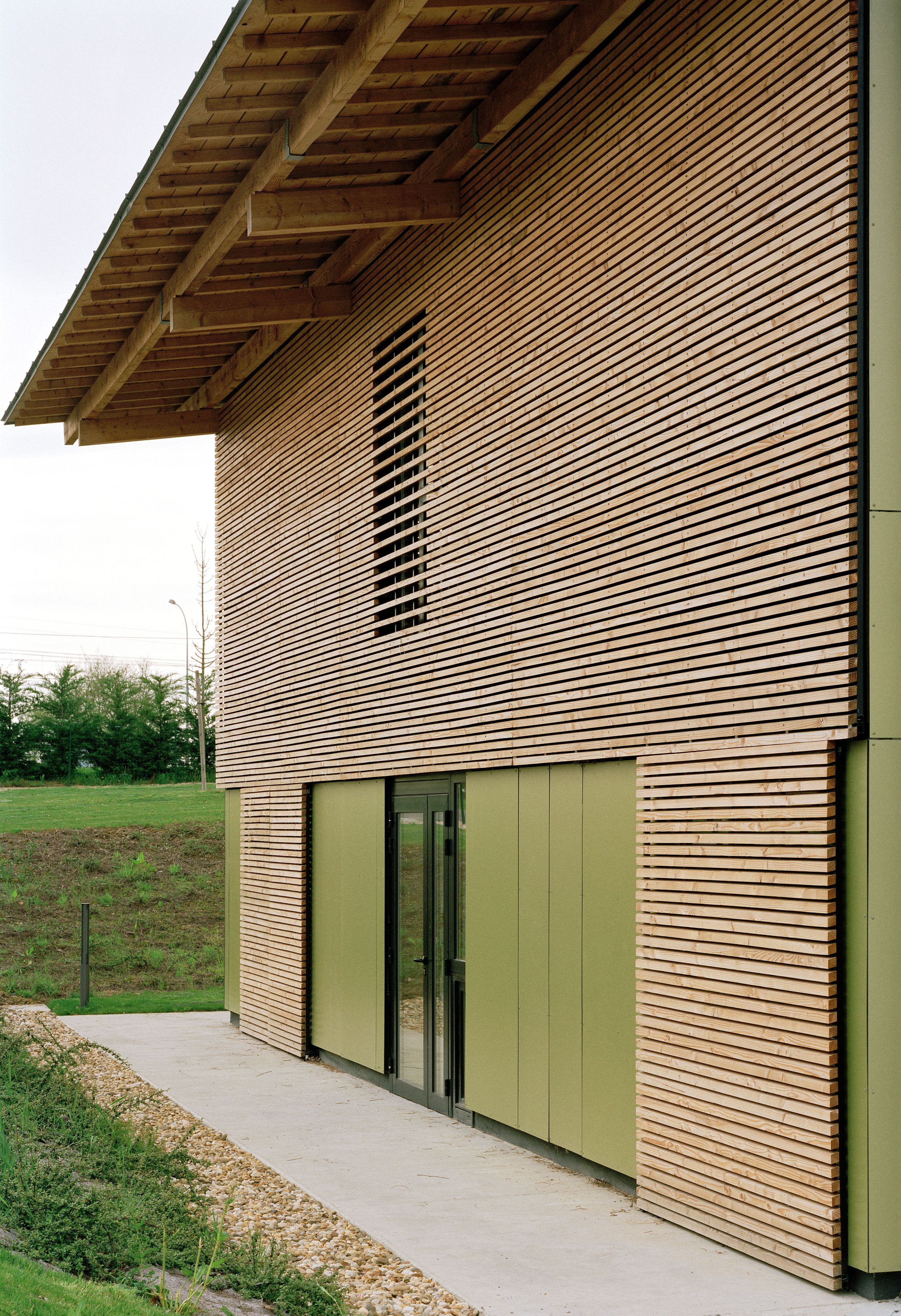 Façade de l’EHPAD de Mervans par Tectoniques, bardage bois ajouré sur panneaux vert olive, large débord de toiture et ouverture vitrée sur le jardin.