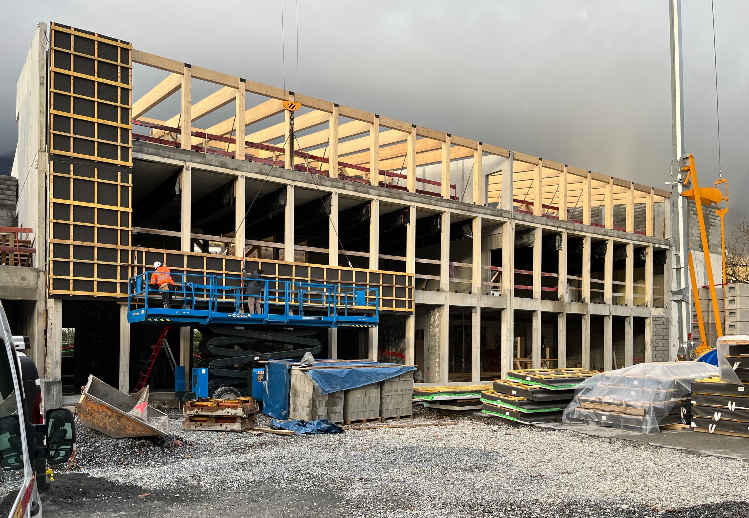 Chantier de transformation du School complex du Bouchet à Bonneville, montrant la surélévation en ossature bois sur la structure béton existante en cours de montage.