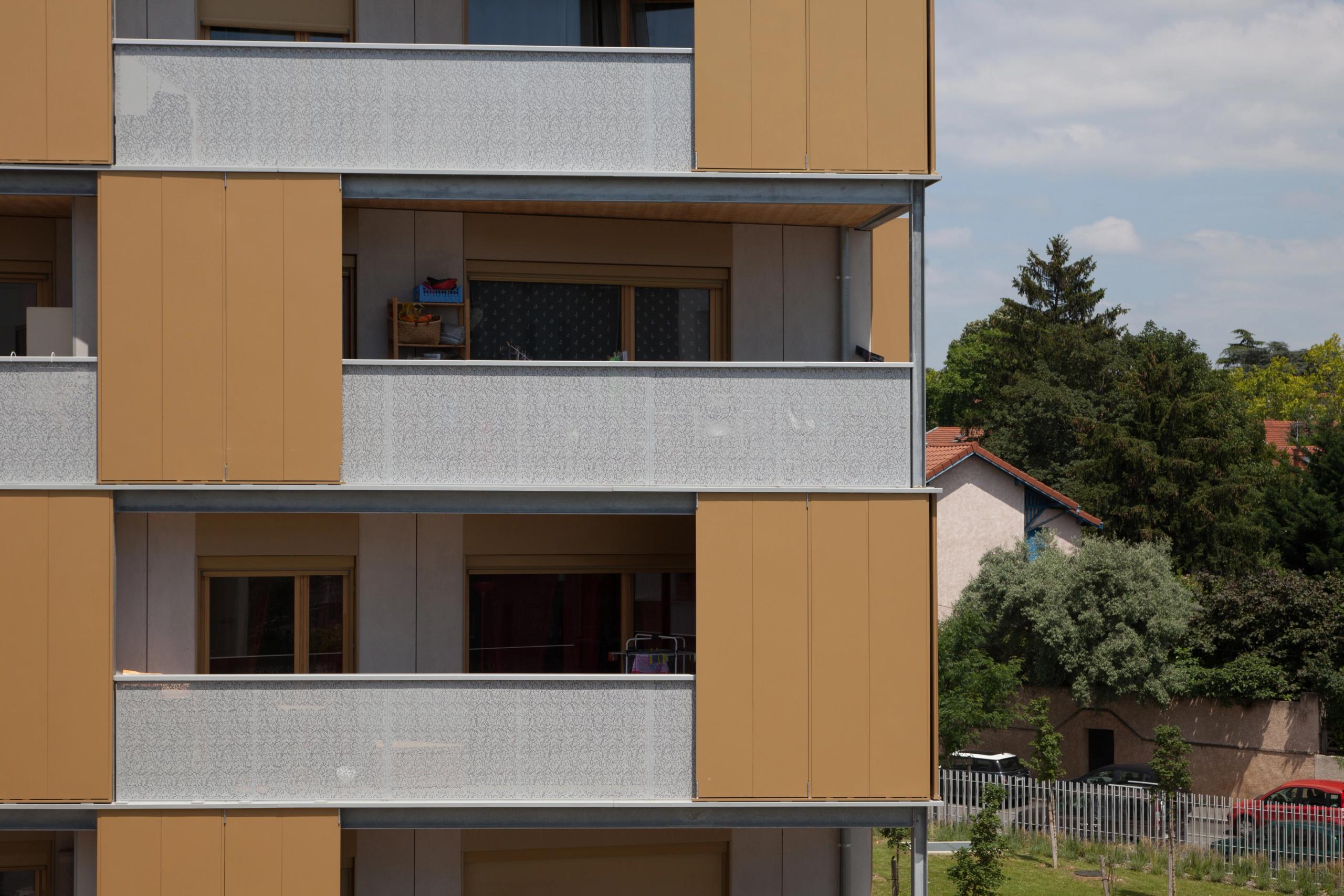 Façade des 55 logements à Lyon par Tectoniques, alternant balcons filants en métal clair, panneaux bois-métal ocre et baies vitrées encastrées.