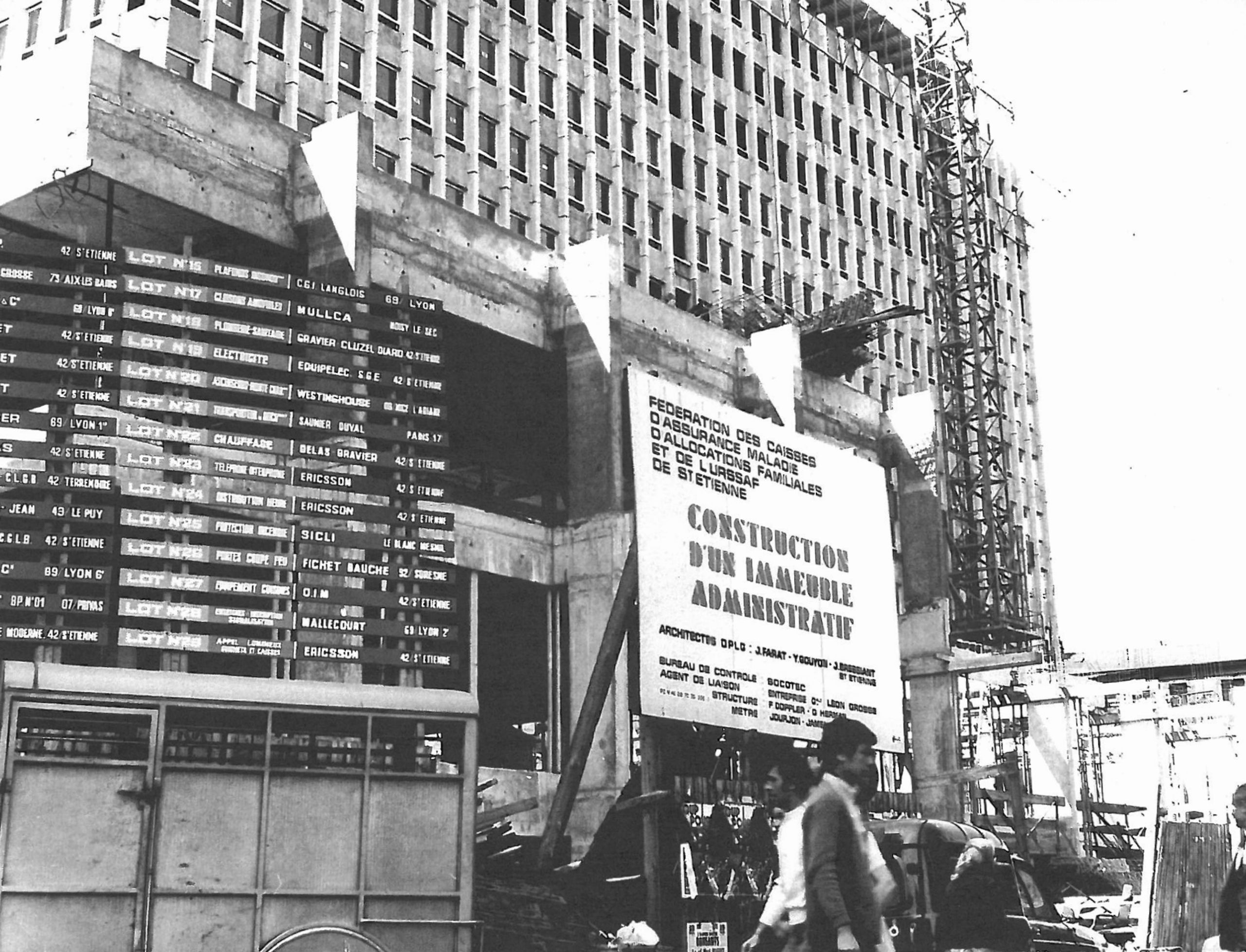 Chantier de l’IGH Émile Loubet à Saint-Étienne dans les années 1970, montrant le socle en béton brut, la tour administrative en cours d’élévation et les échafaudages.