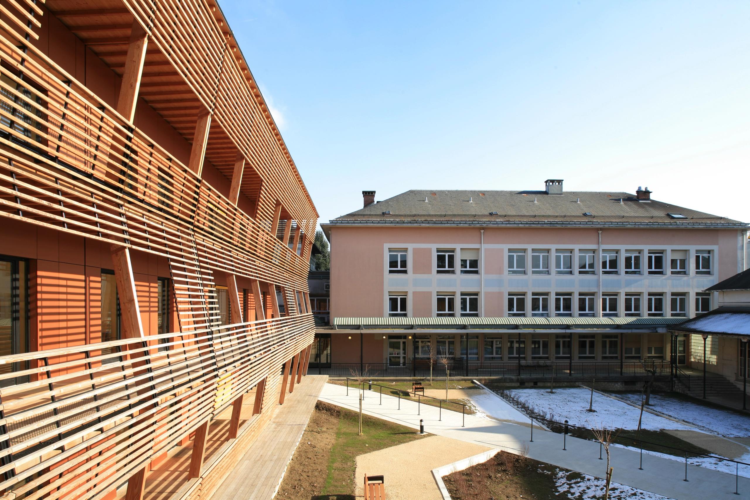 Extension de l’EHPAD de Chambéry par Tectoniques : volume en T à façades bois à claire-voie, grandes terrasses sur jardin paysager, en lien avec le bâti existant.