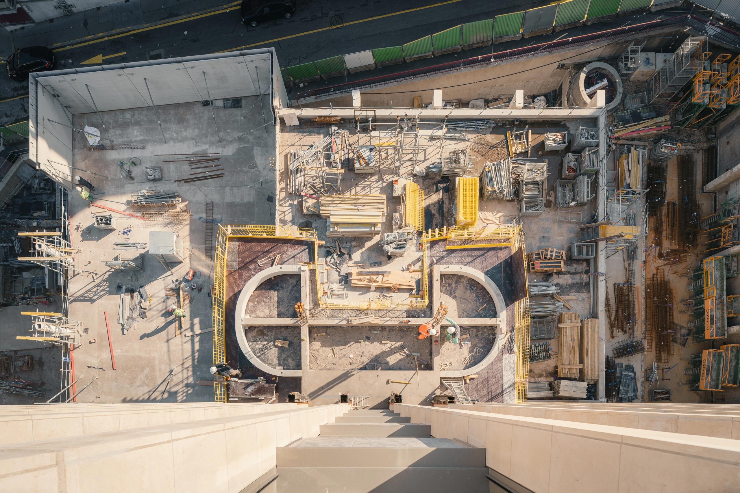 Vue aérienne du chantier de réhabilitation de l’IGH Émile Loubet à Saint-Étienne, montrant le socle curé, les voiles courbes et la nouvelle trame structurelle.