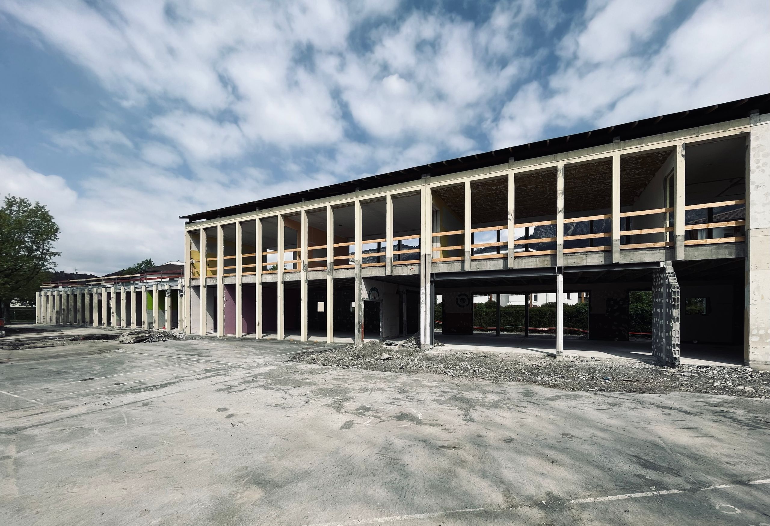 Vue du chantier de restructuration du groupe scolaire du Bouchet à Bonneville, montrant la trame en béton existante mise à nu et les futurs volumes ouverts en R+1.