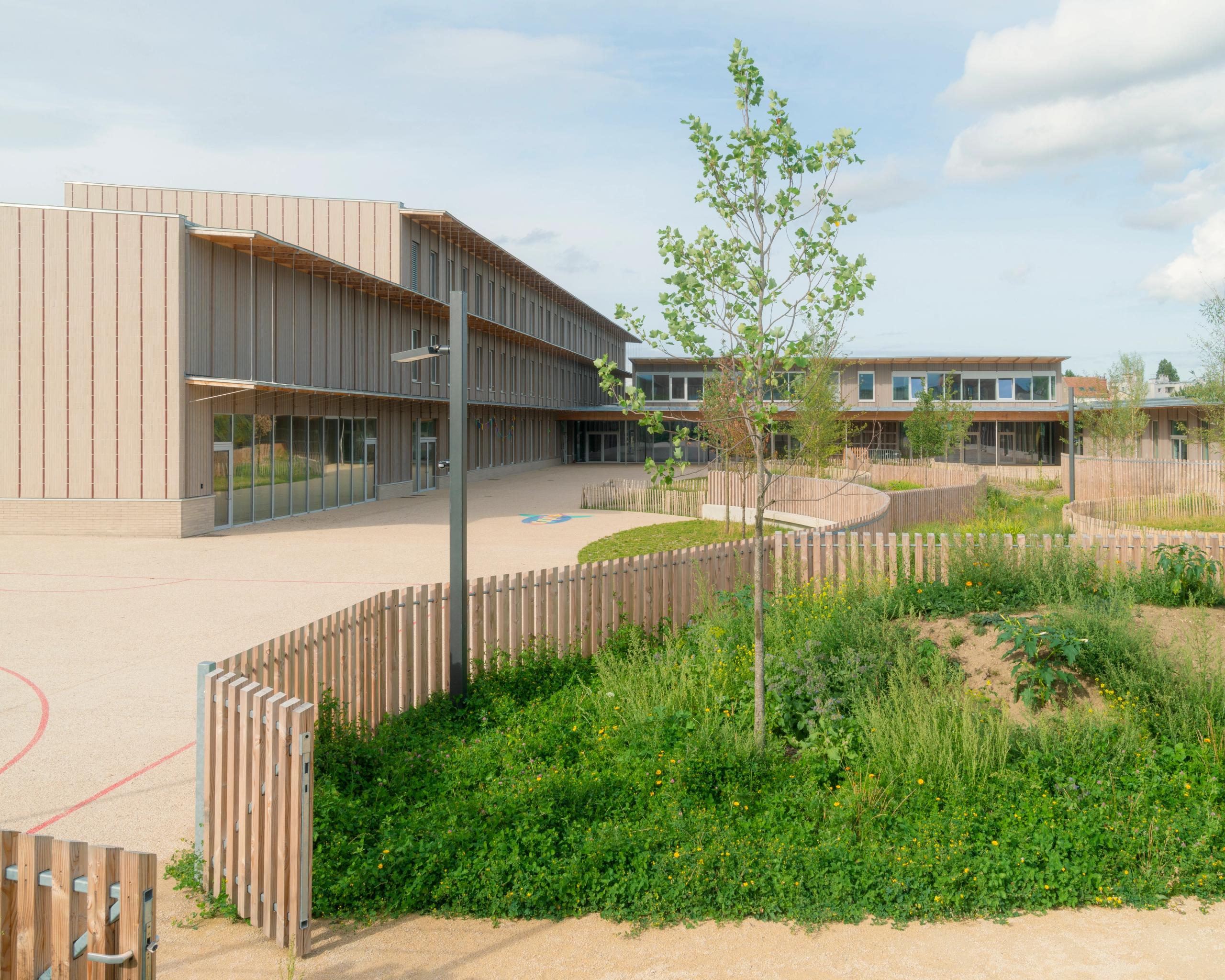 Vue des groupes scolaires Jacqueline Auriol et Jean Jaurès au Bourget : volumes en U, façades bois et vitrées, cours minérales et jardins plantés.