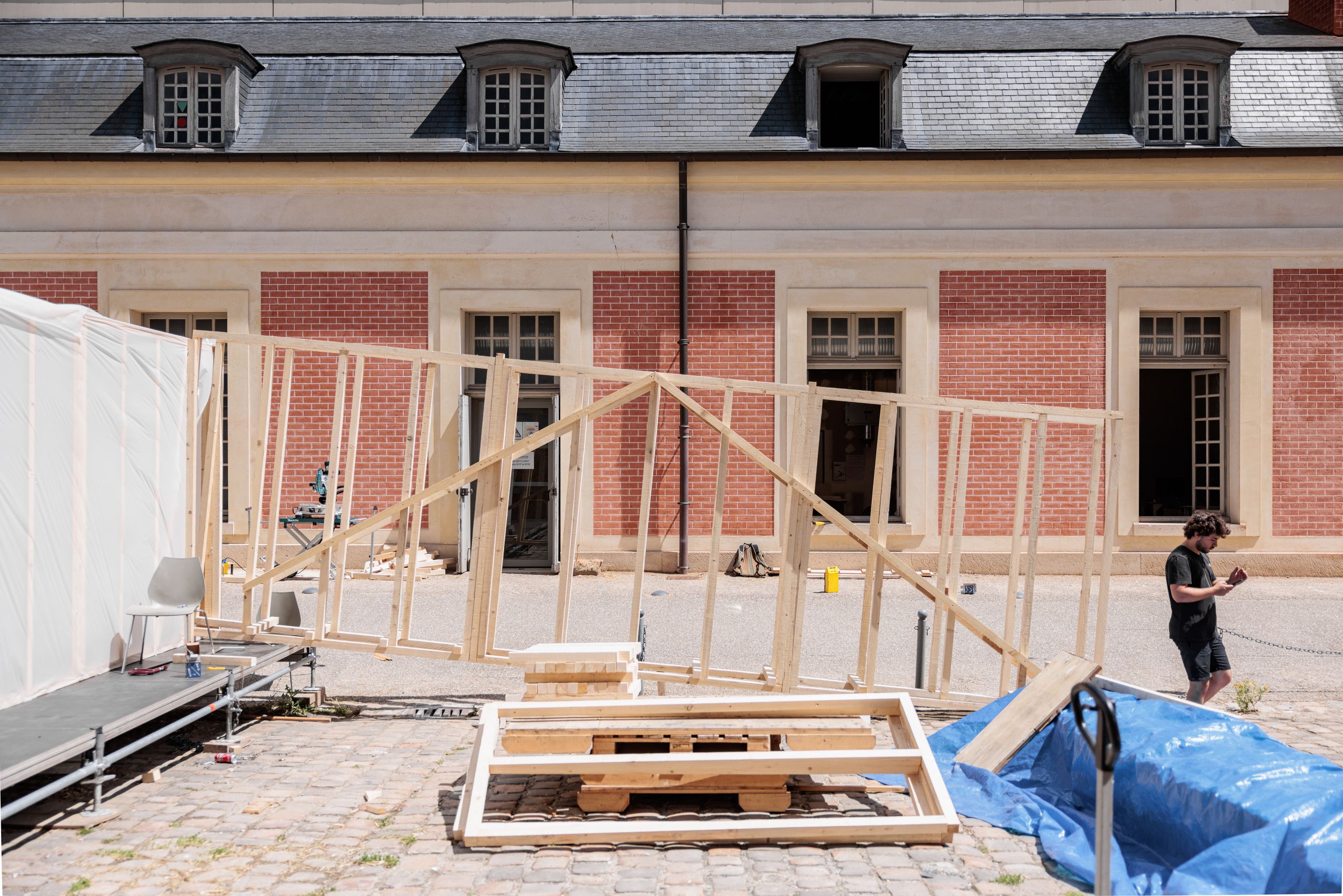 Structure en ossature bois 60x60mm en cours de montage du workshop 60x60 à Versailles, installée dans la cour pavée de l’école d’architecture.