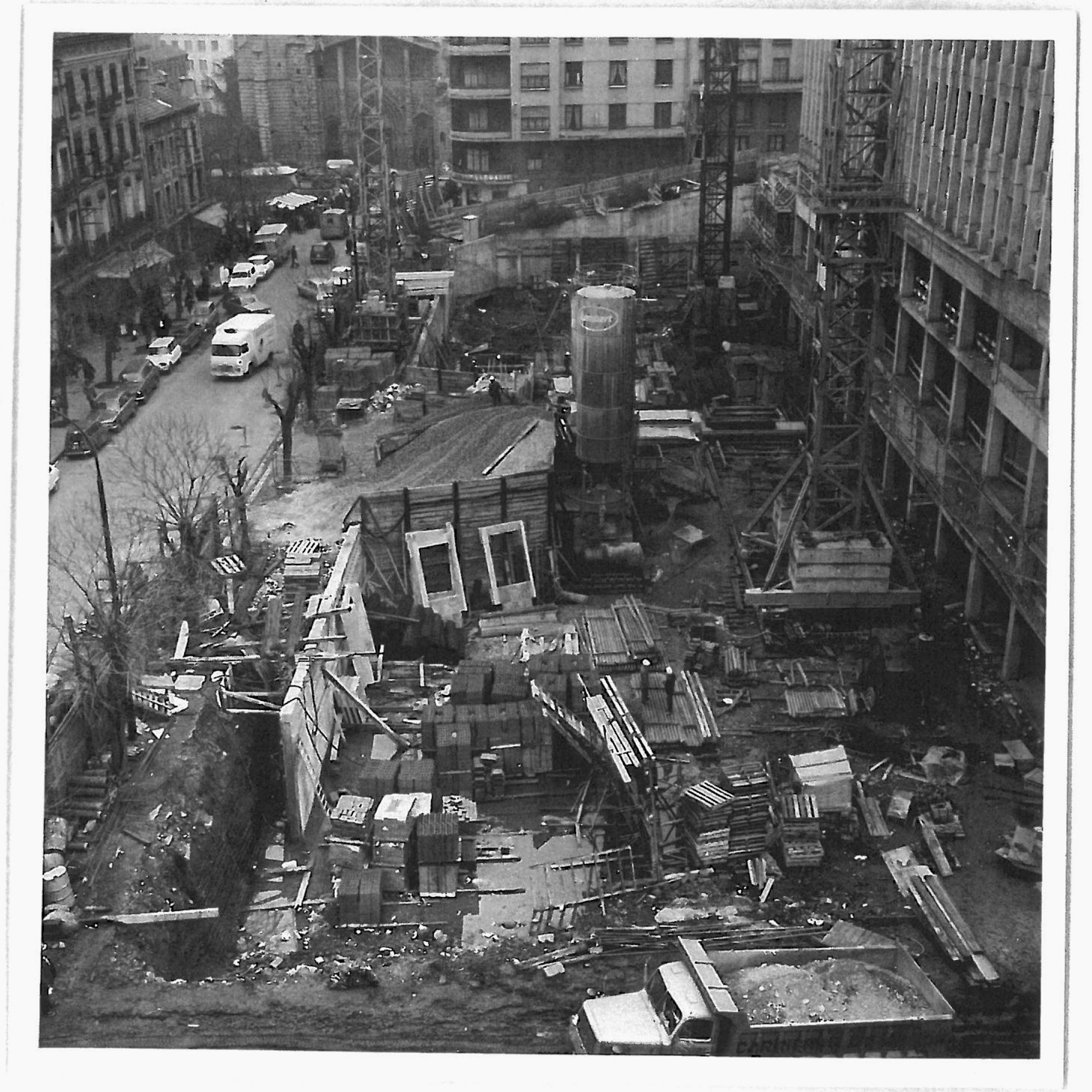Chantier historique de l’IGH Émile Loubet à Saint-Étienne, vue d’ensemble du socle en construction, grues, coffrages béton et structure urbaine dense.