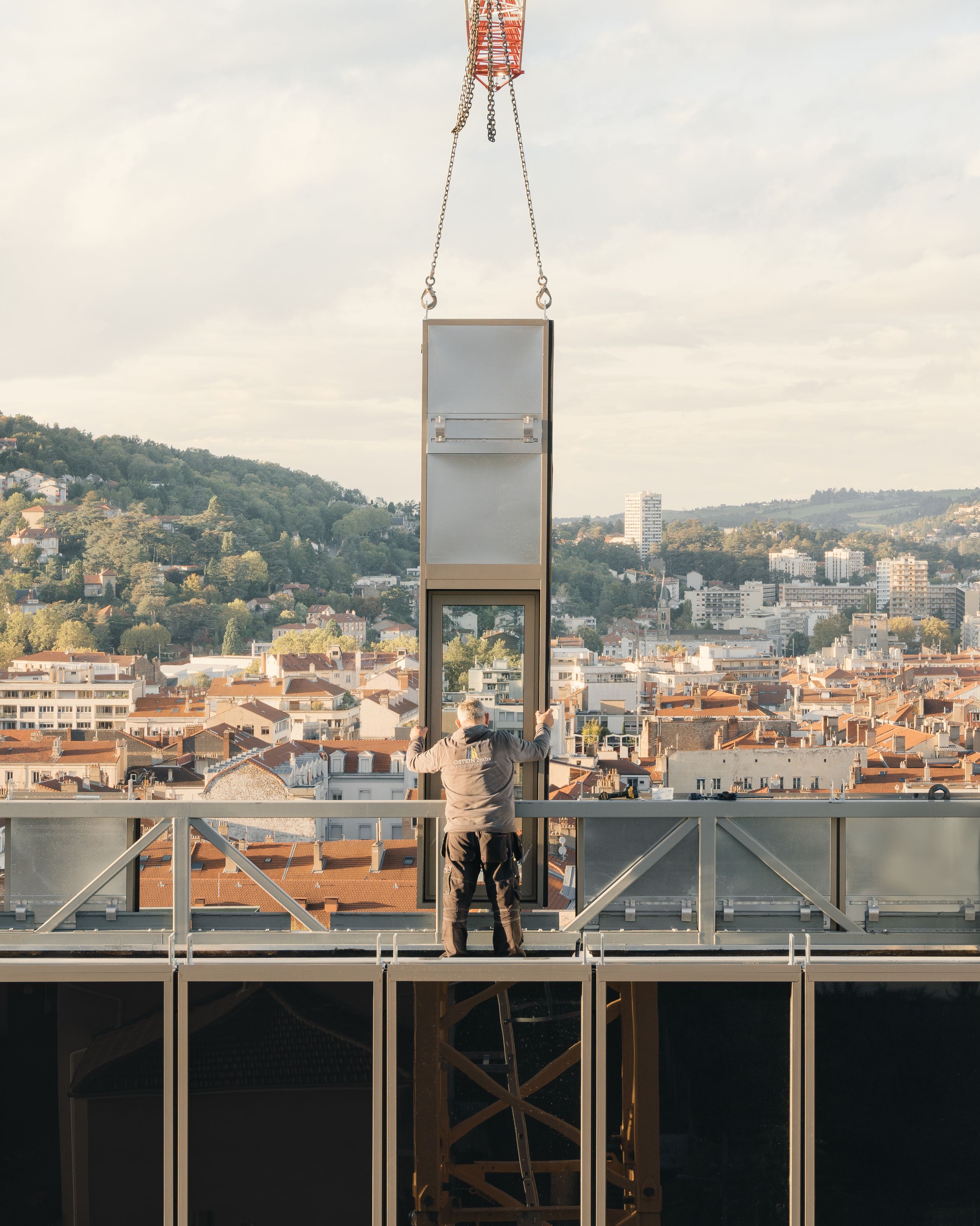 Chantier de réhabilitation de l’IGH Émile Loubet à Saint-Étienne : pose d’un module de façade vitré en hauteur, structure métallique ouverte sur la ville.