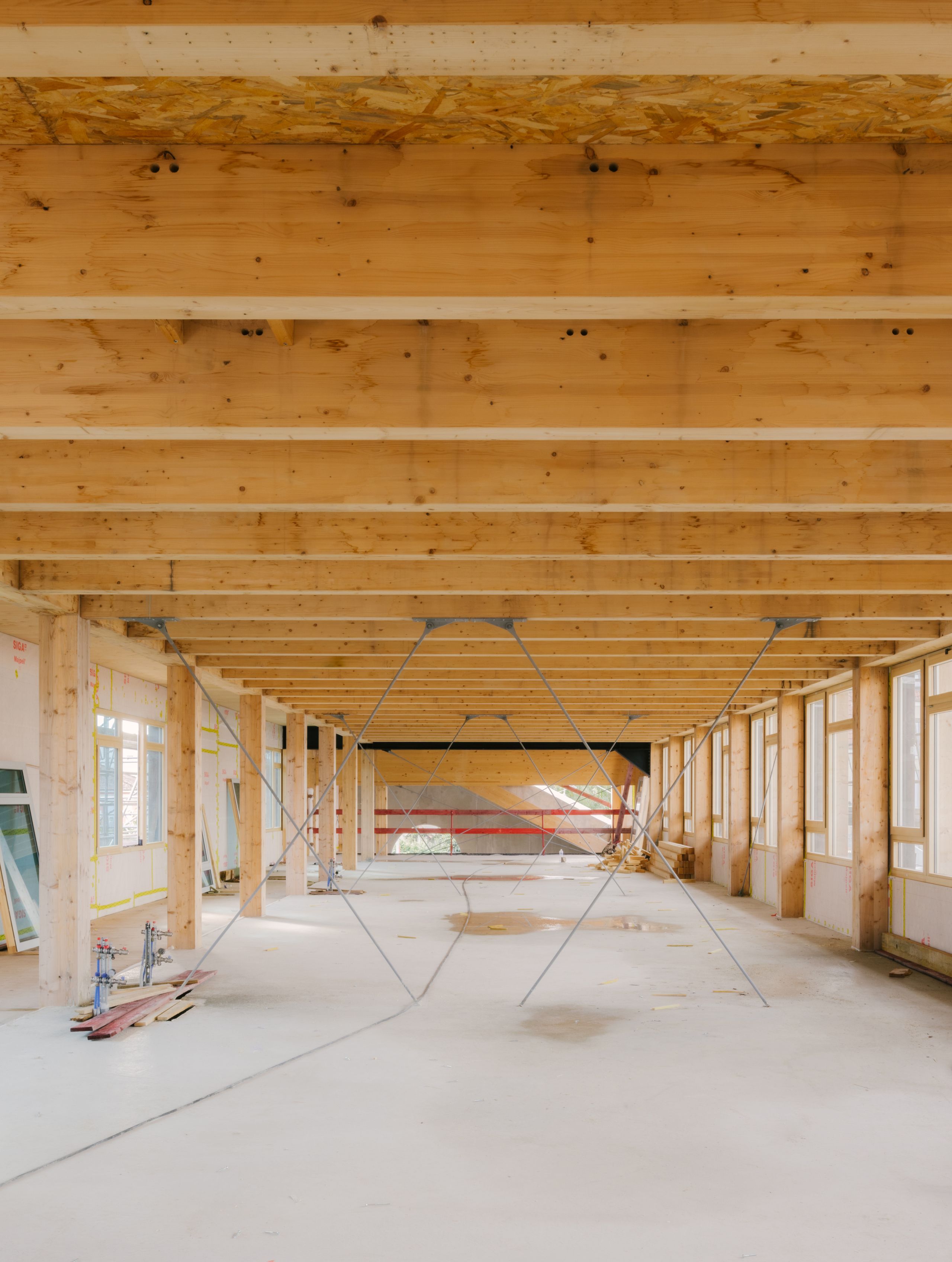 Chantier du groupe scolaire Dominique Frelaut à Colombes : grand plateau structure bois, plan libre, contreventements métalliques et façades largement vitrées.