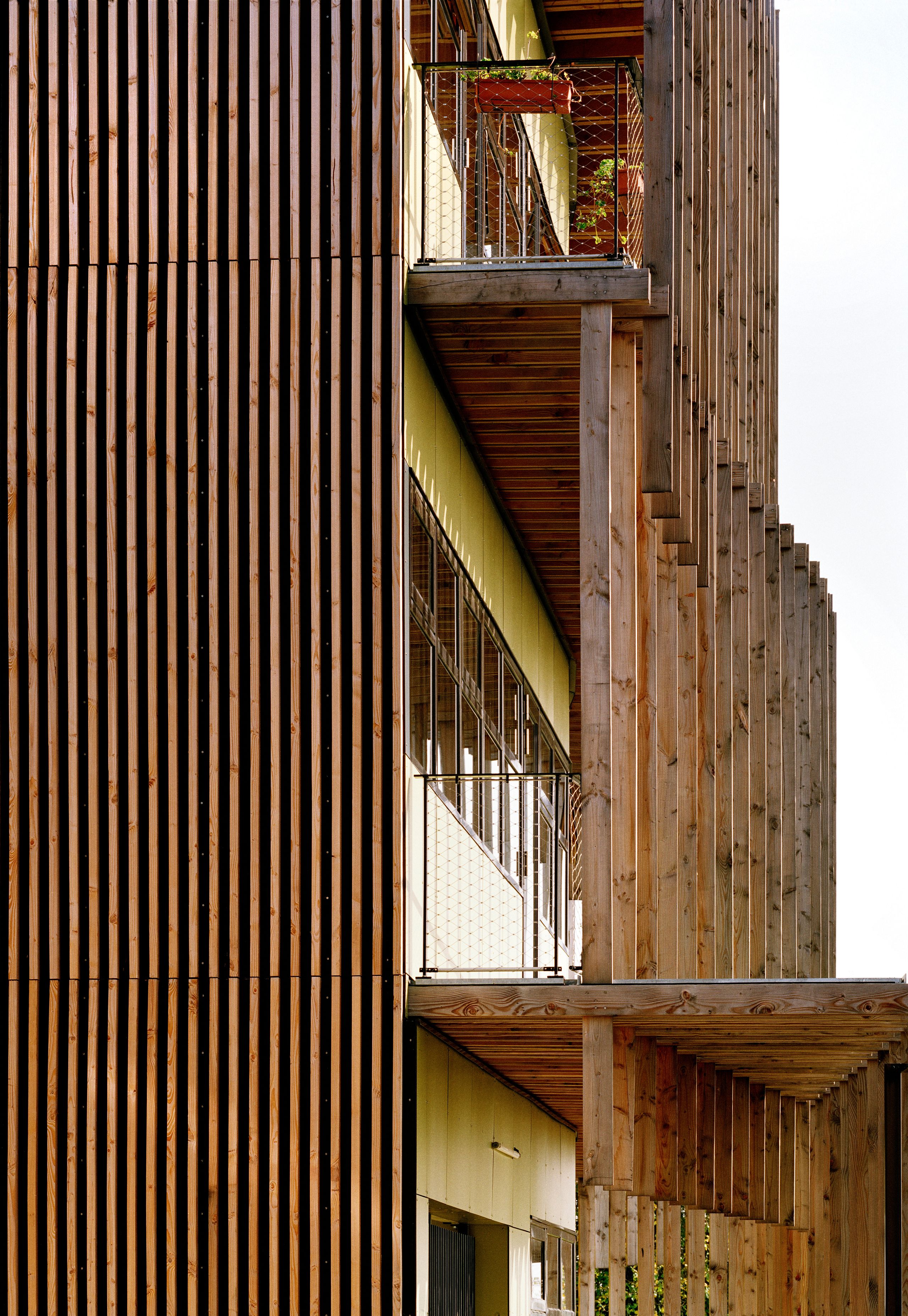 Façade du laboratoire INRAE à Champenoux par Tectoniques, galerie bois à claire-voie, structure poteaux-poutres et bandeau vitré sur atrium central.