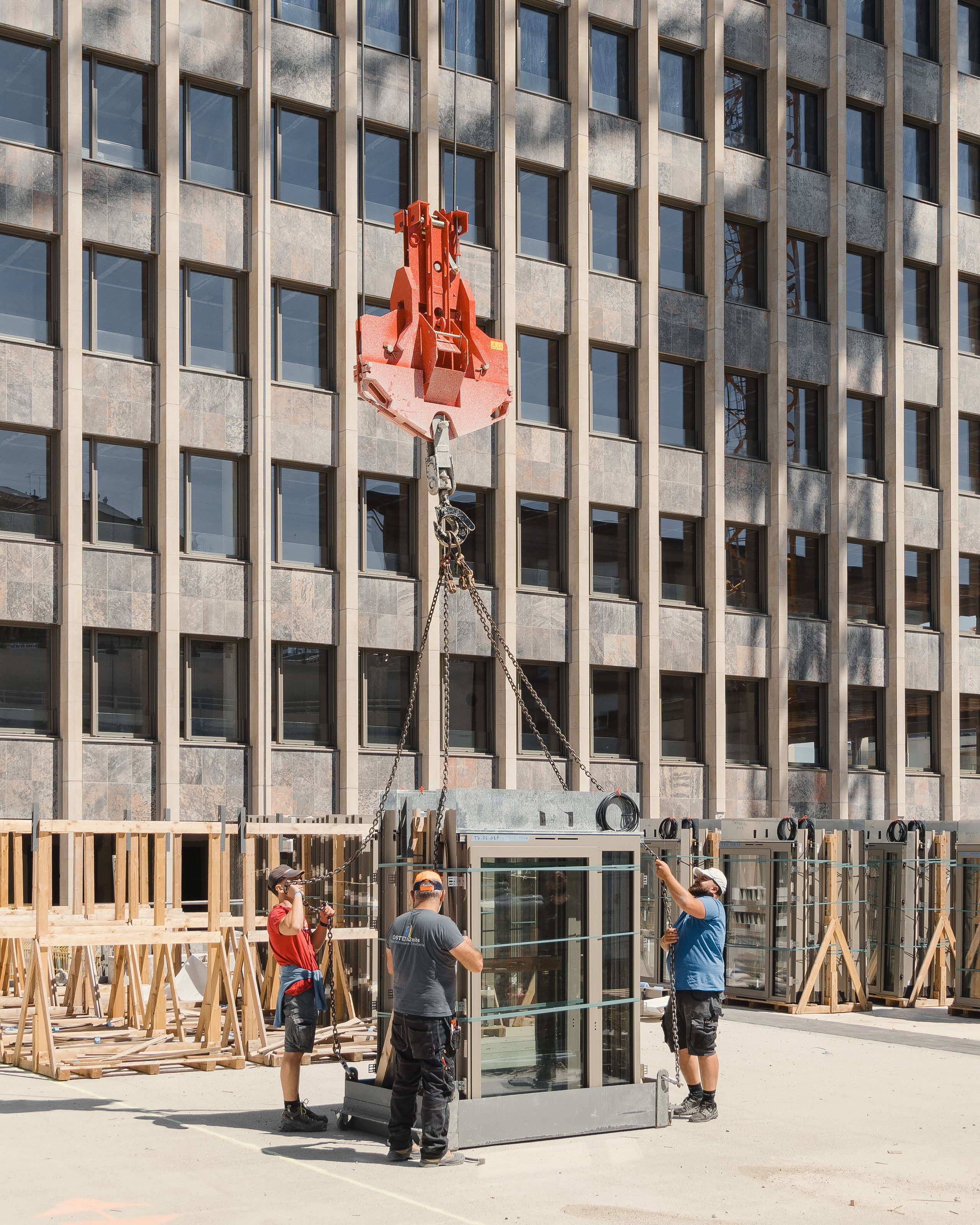 Chantier de réhabilitation de l’IGH Émile Loubet à Saint-Étienne : pose de nouveaux modules de façade vitrés devant la trame bétonnée existante.