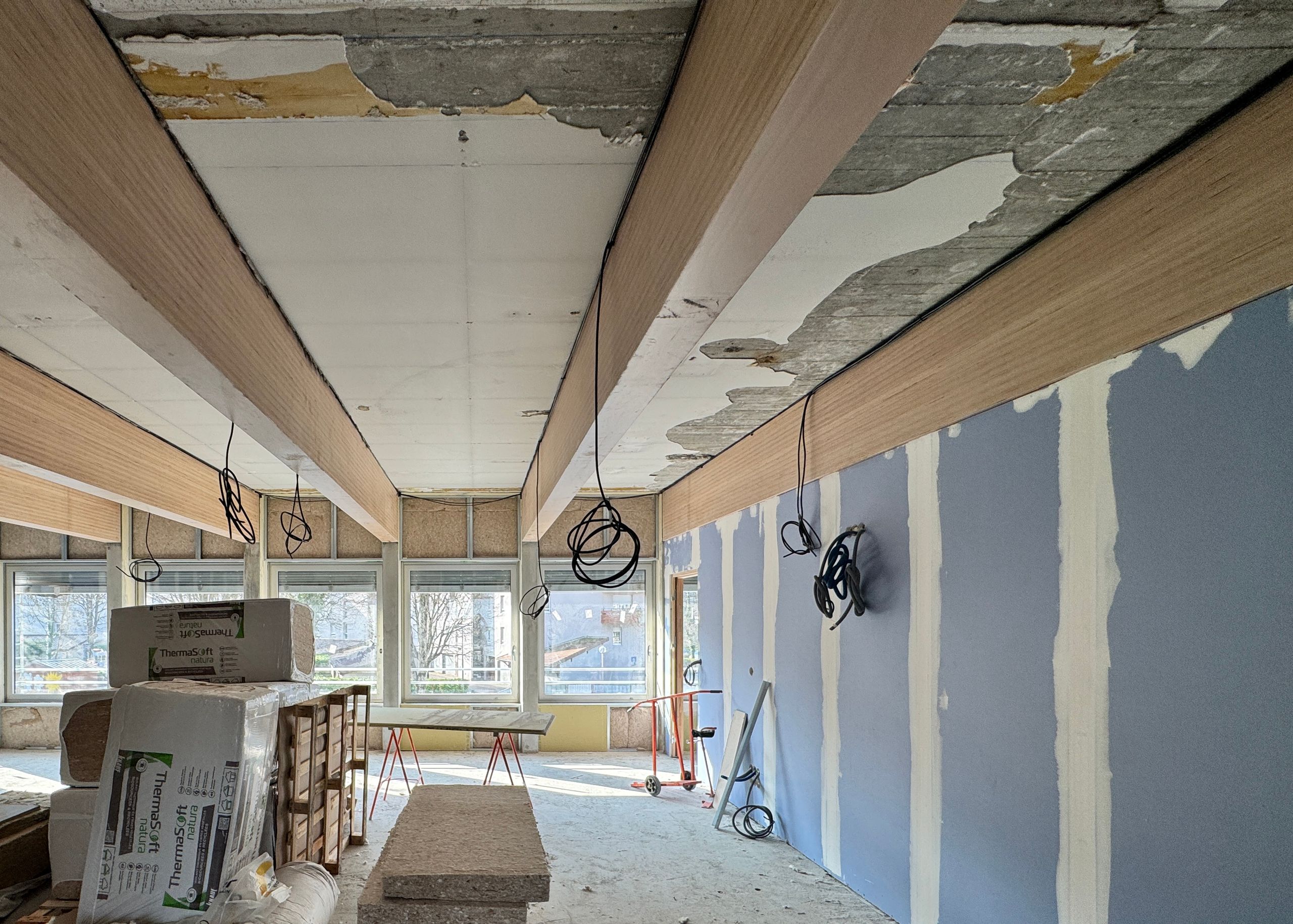 Vue intérieure du chantier de restructuration du School complex du Bouchet à Bonneville, montrant la trame béton existante, les nouveaux doublages et l’ossature en cours de pose.