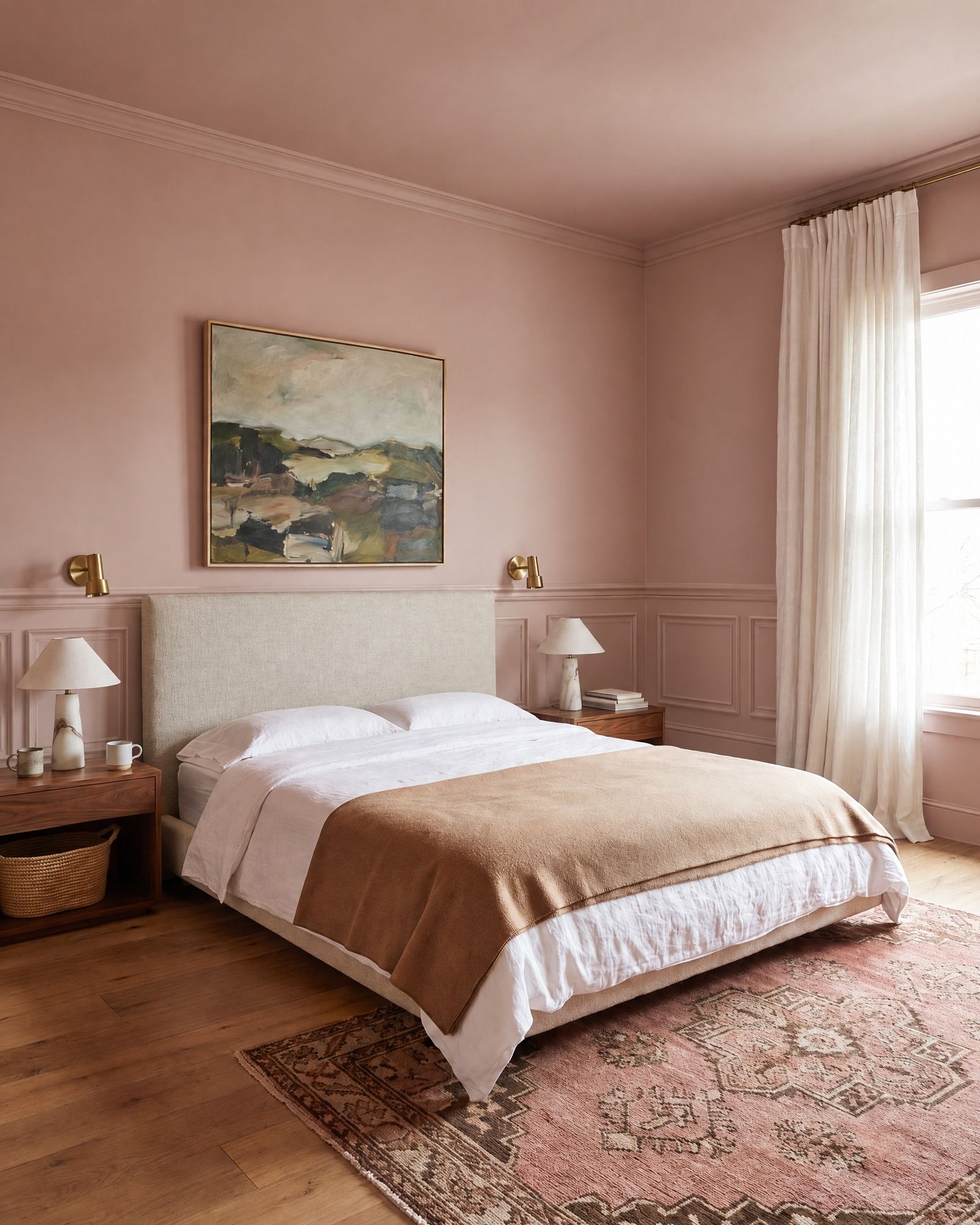 A plaster-pink bedroom with a linen headboard and a landscape painting, a chair rail with short panels of molding below it running behind the bed, with a crown above