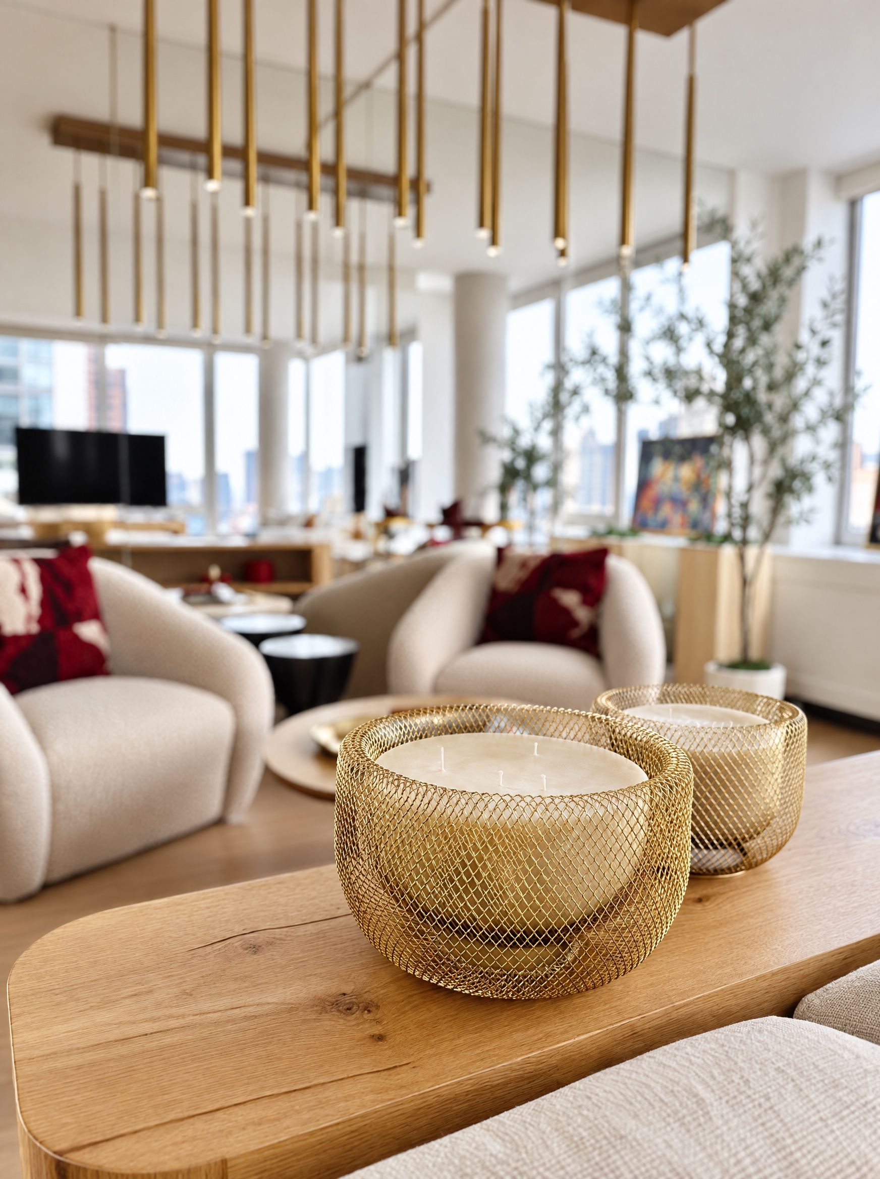 Two gold wire-mesh candle holders on the oak console, the armchairs soft in the background