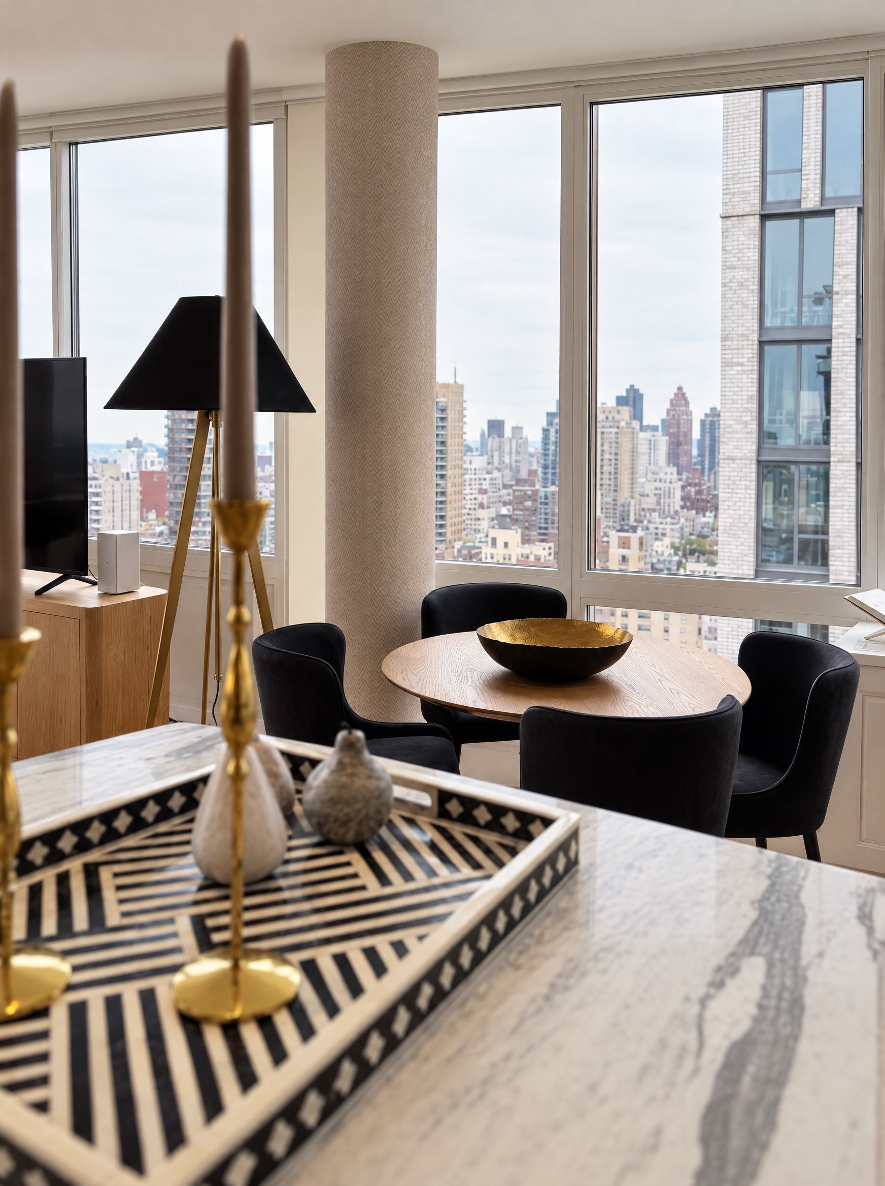 The dining table and the skyline seen across the island, past the brass candlesticks
