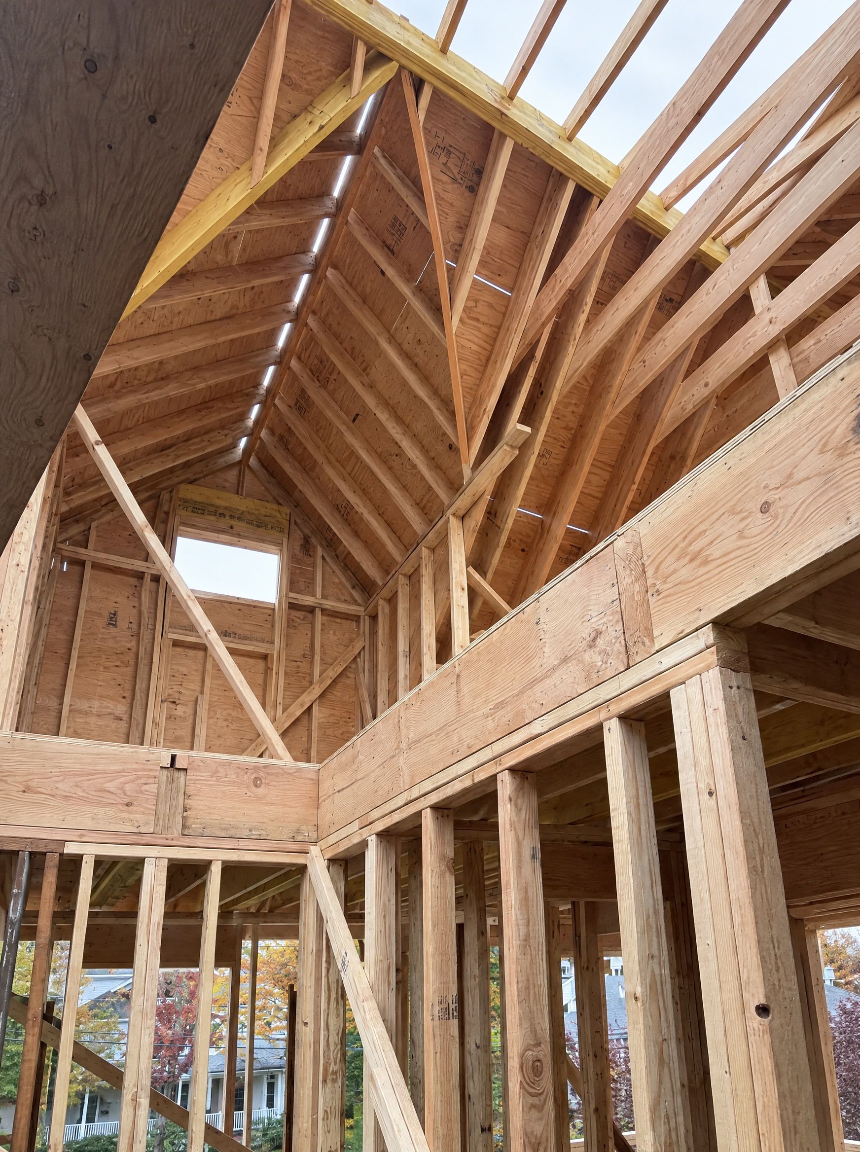 Inside the attic frame: rafters meeting at the ridge and the gable window opening