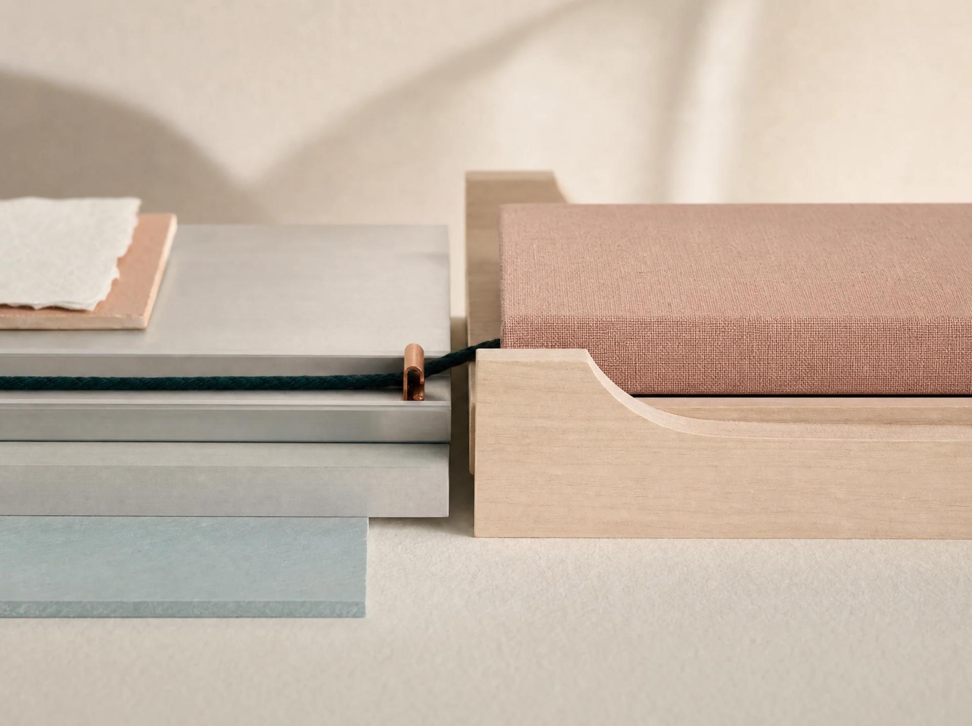 Teal cord transfers intact from a blue mineral platform to a blush fabric-covered block through a copper guide.