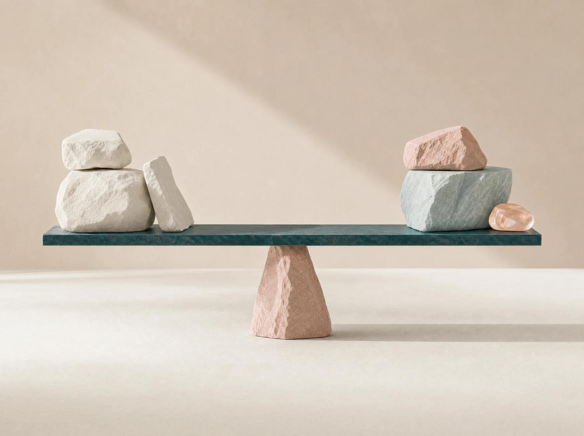 A teal balance beam holding two unequal groups of mineral forms in deliberate equilibrium.