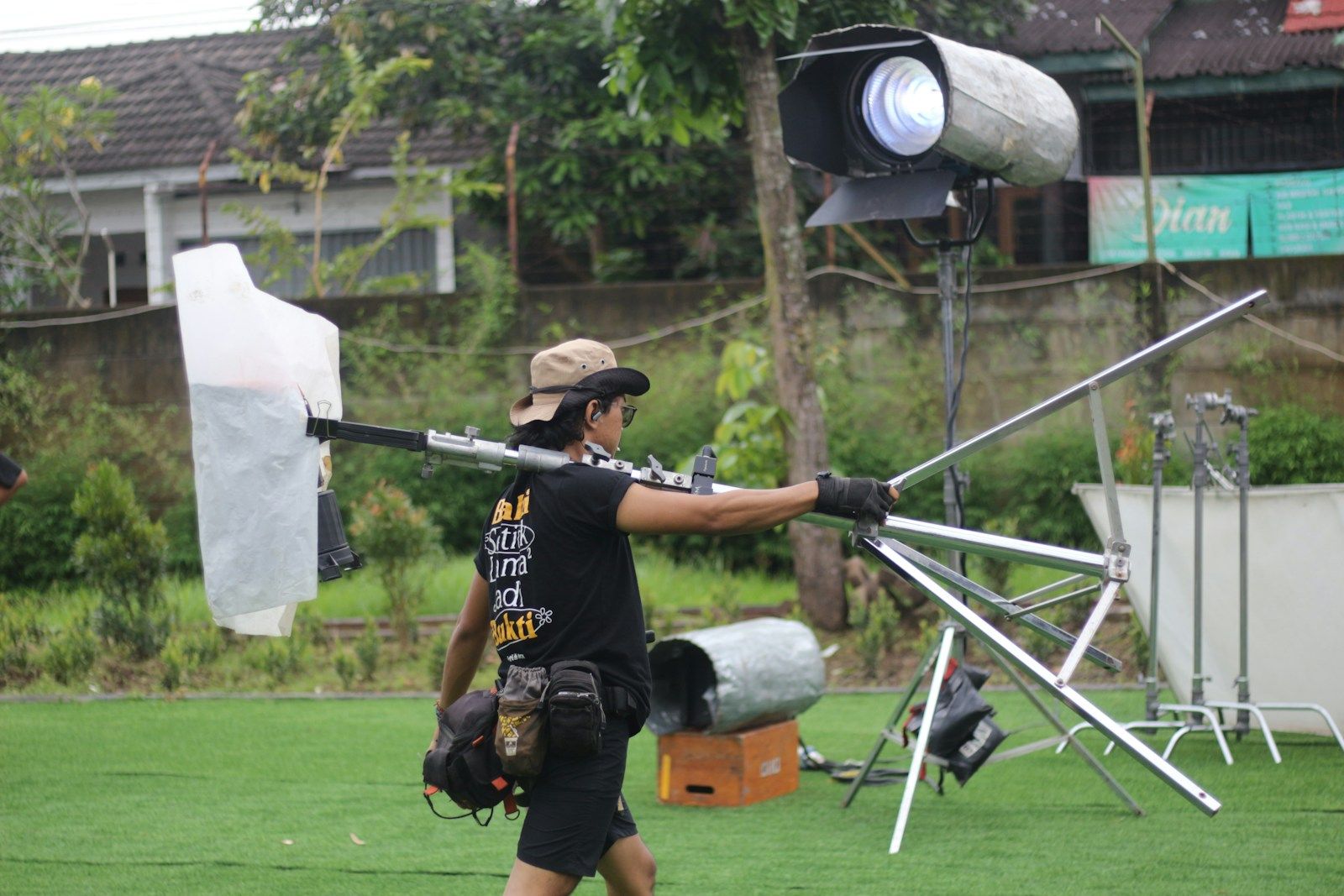Crew member carrying lighting equipment on set as a tech recce planning reference