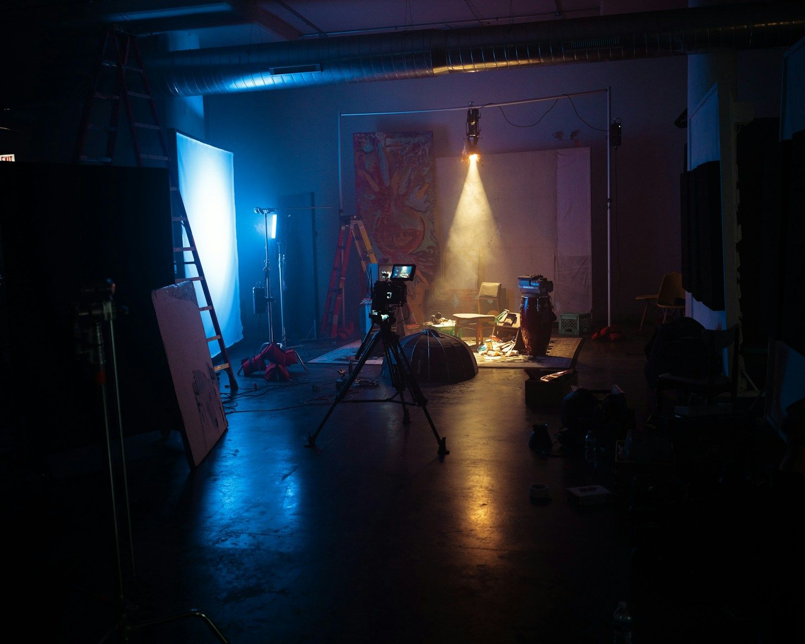 Film camera and studio lighting in a dark production room for comparing studio rental, real locations and set build