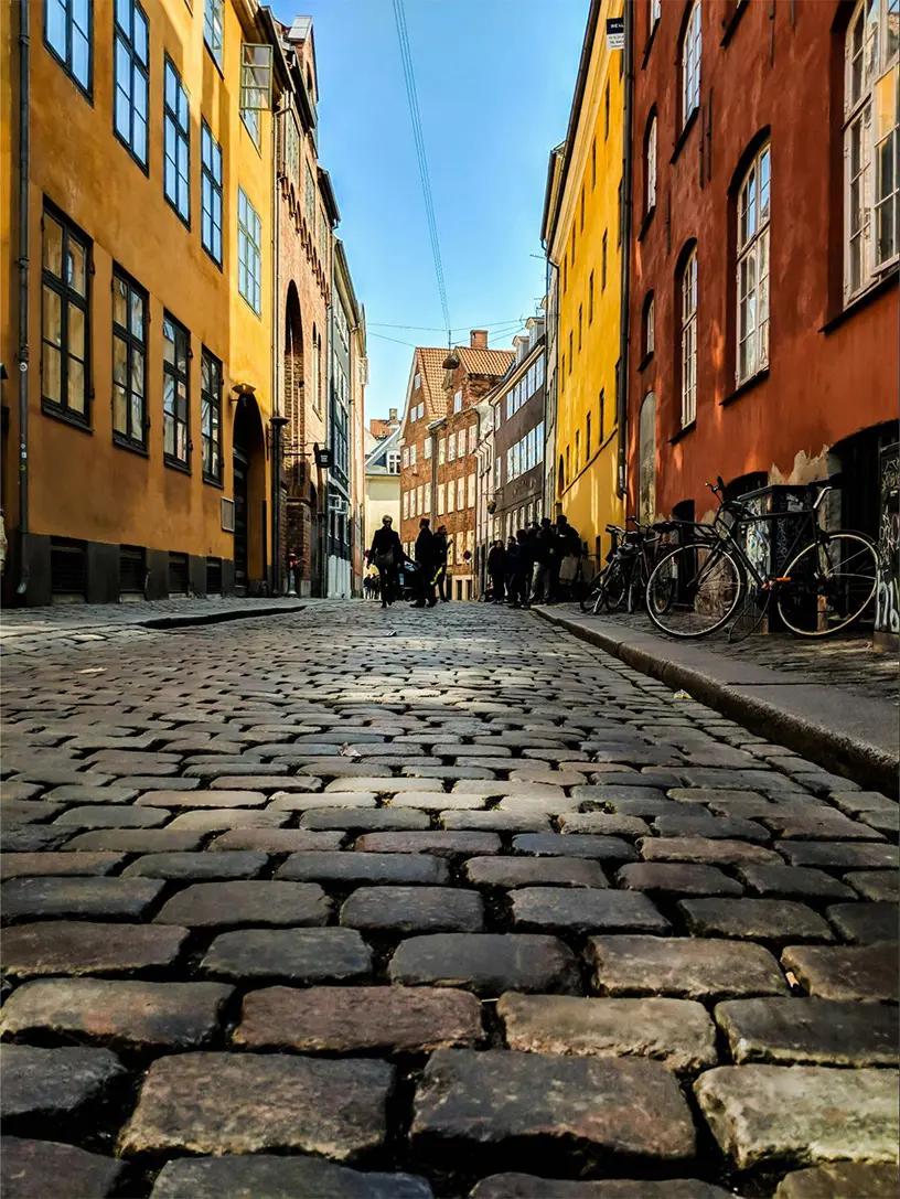 Brostensbelagt gade i København med charmerende andelslejligheder