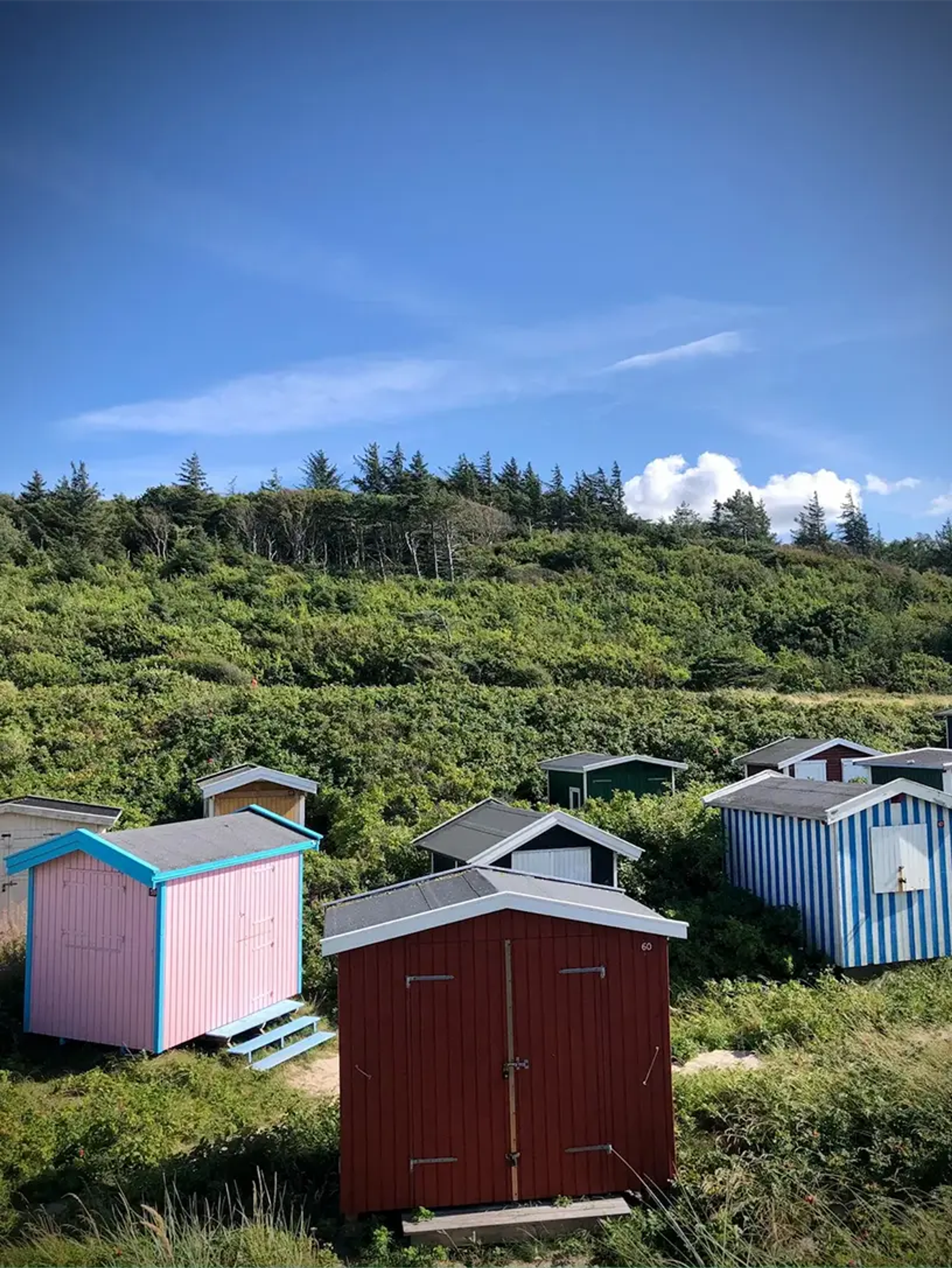 Små bådhuse der symboliserer sommerhus i Danmark.