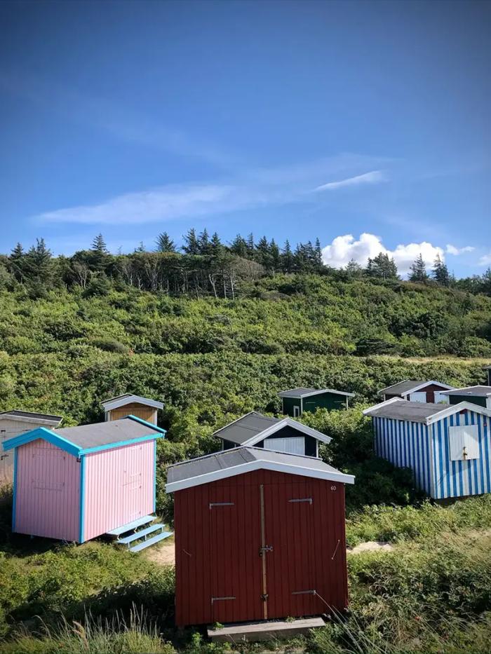 Små bådhuse der symboliserer sommerhus i Danmark.