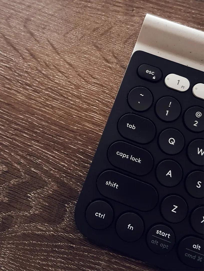 Et sort computertastatur på et træbord