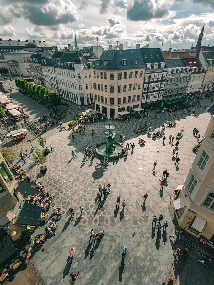 Luftfoto af Amagertorv i København med Storkespringvandet og travle mennesker