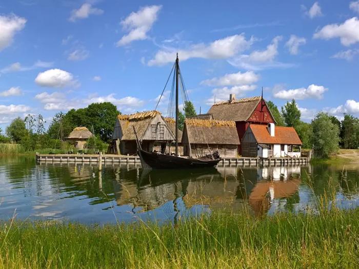 Et træhus ved en sø med en båd ved siden af.