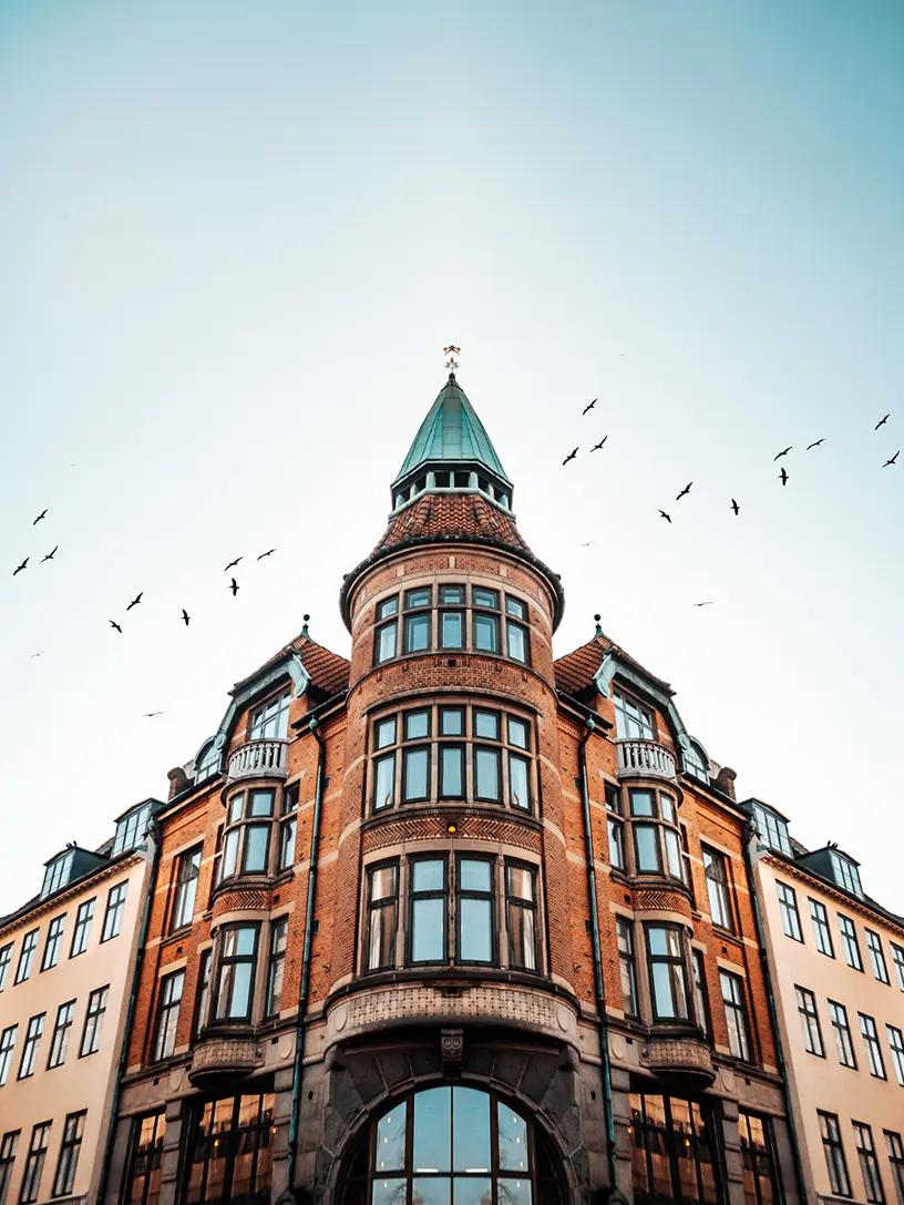 En bygning med fugle, der flyver henover, annonceres for et lån til bolig.