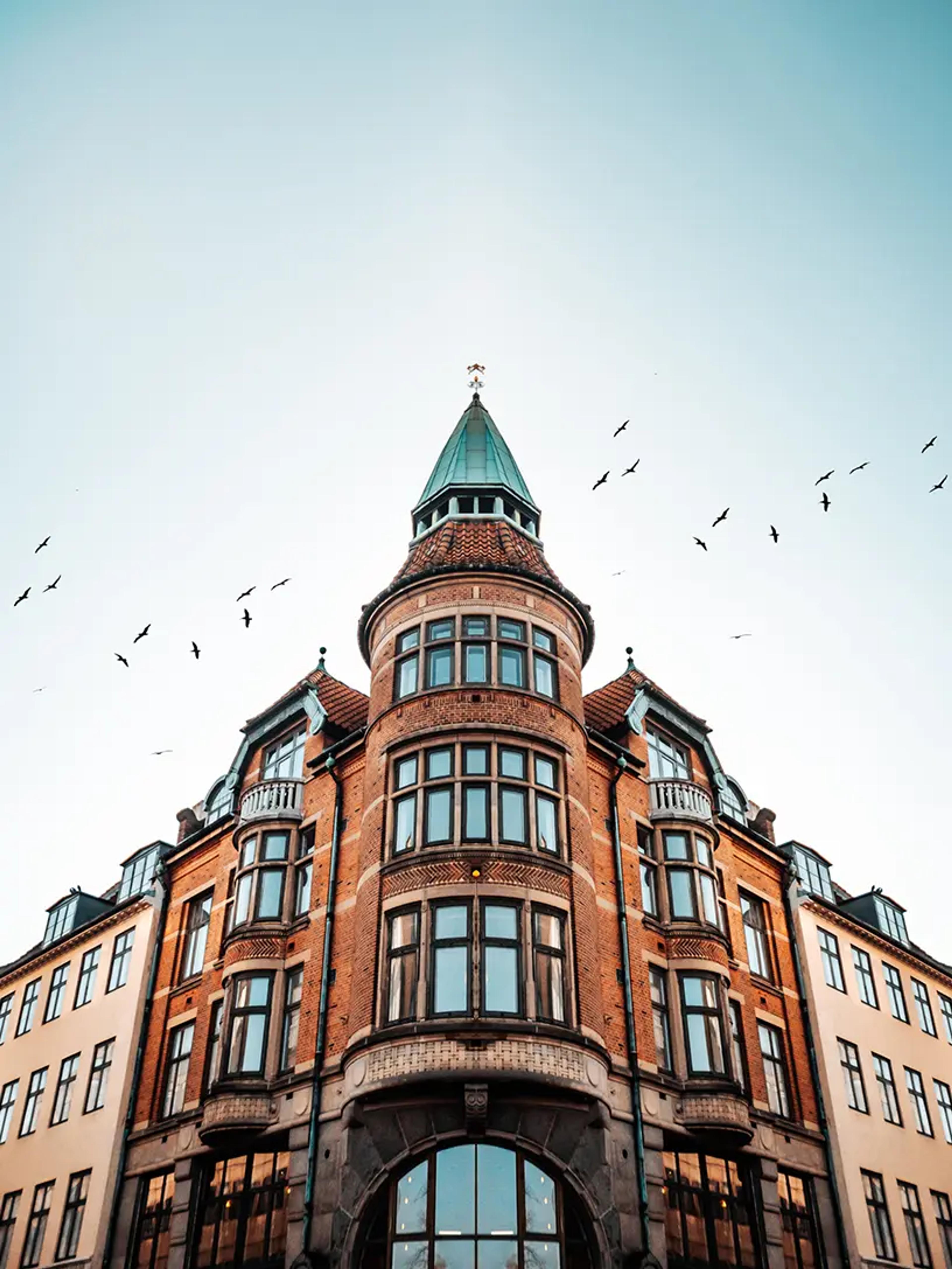 En bygning med fugle, der flyver henover, annonceres for et lån til bolig.