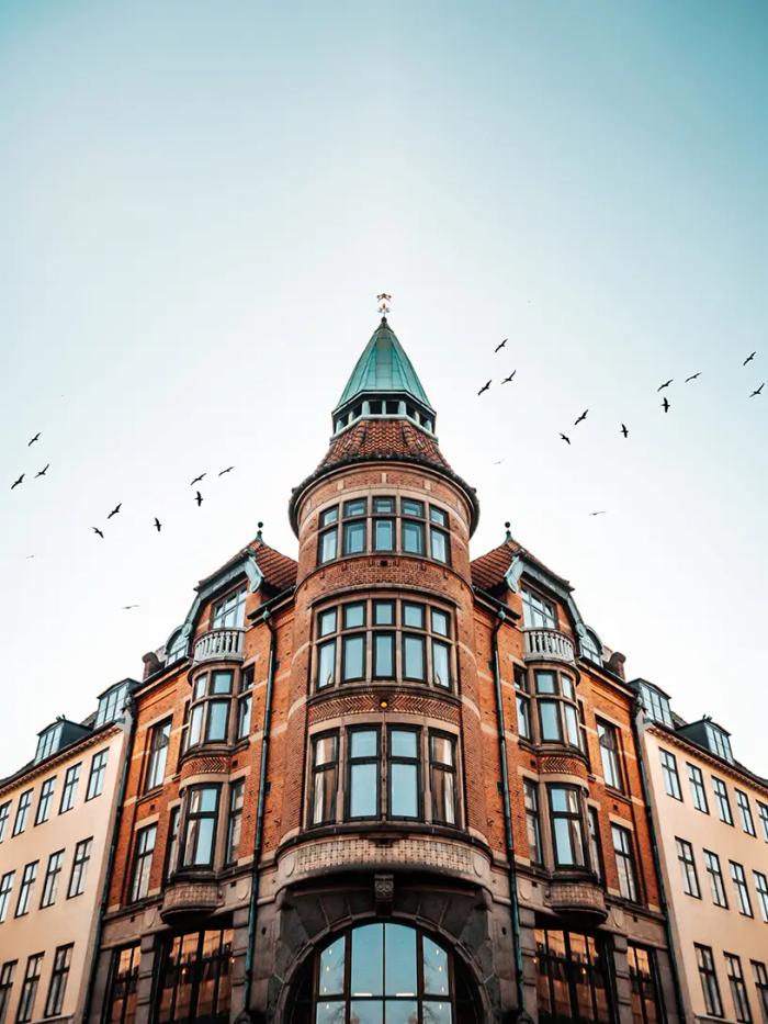 En bygning med fugle, der flyver henover, annonceres for et lån til bolig.