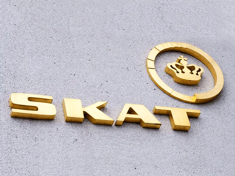 Et gyldent skilt med ordet skat på, der repræsenterer en ejendomsvurdering for året 2022 og 2023.