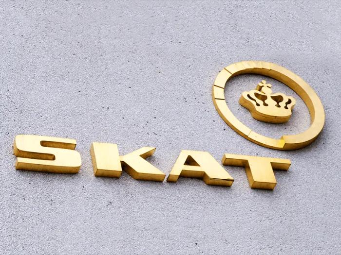 Et gyldent skilt med ordet skat på, der repræsenterer en ejendomsvurdering for året 2022 og 2023.