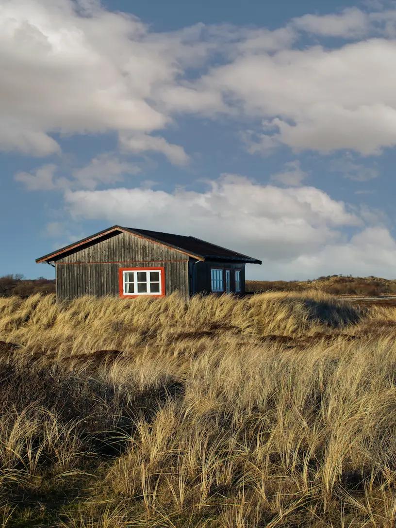 Et træhus i sandet.